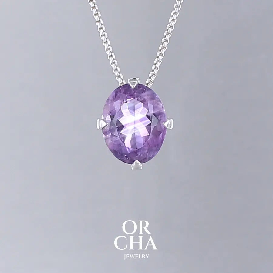 Collier solitaire pour femme en argent massif sertie d'une Améthyste. Pierre facettée de forme ovale de qualité transparente, inclusions. Pierre naturelle de couleur violet clair type rose de France. Pendentif monté sur une chaine en argent sterling de type maille vénitienne de 1,3 mm d'épaisseur et de 40 cm de longueur. Bijoux unique, éthique et durable présenté dans un coffret de notre marque, prêt à offrir. Livraison offerte, certificat d'authenticité, service client.

