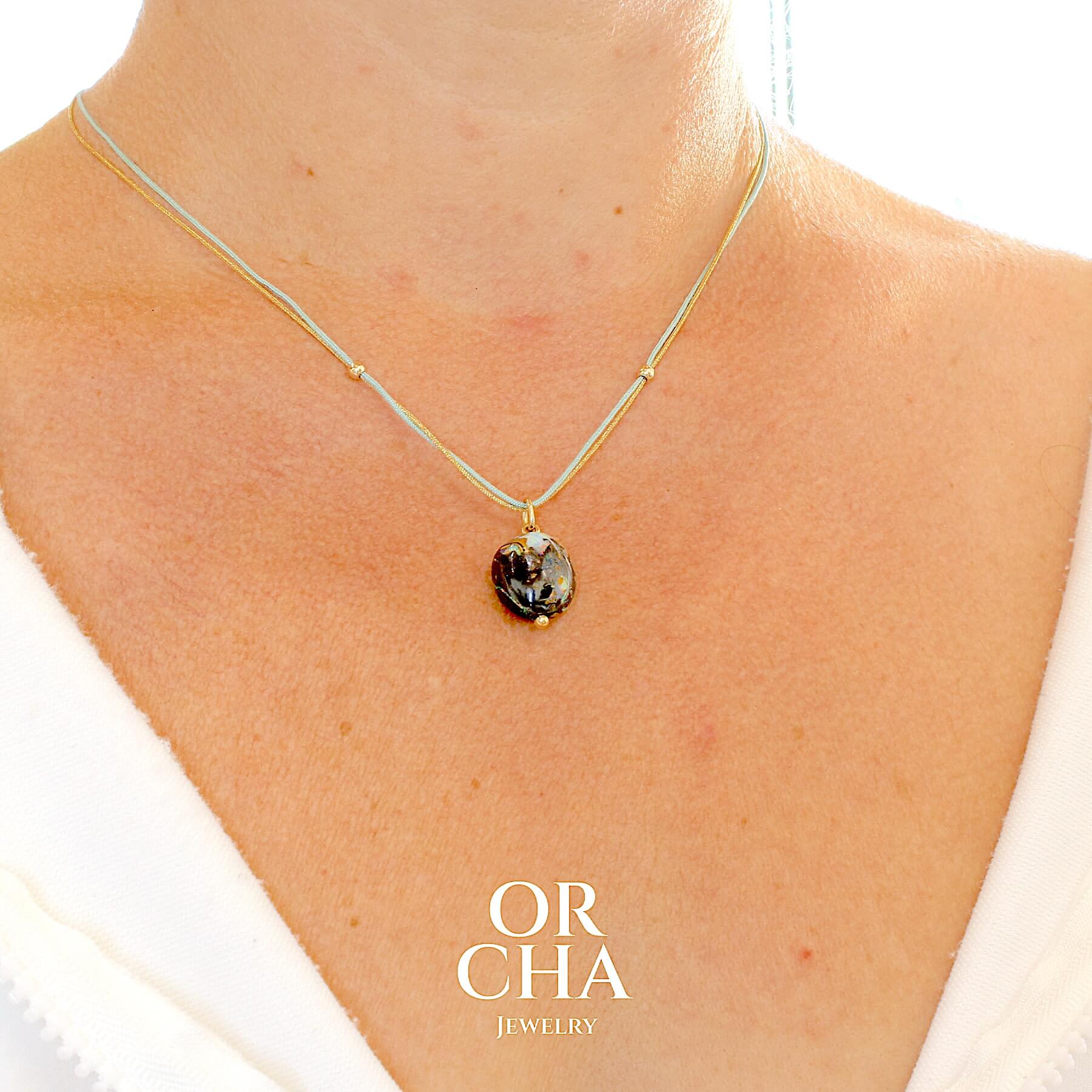 Collier perle d'opale boulder sertie en or 18k. Le pendentif est monté sur un collier de deux cordes: une doré scintillante et l'autre verte clair, les apprêts utilisé sont en Gold filled ( or laminé ) Bijoux unique, éthique et durable présenté dans un coffret de notre marque, prêt à offrir. Livraison offerte, certificat d'authenticité, service client.