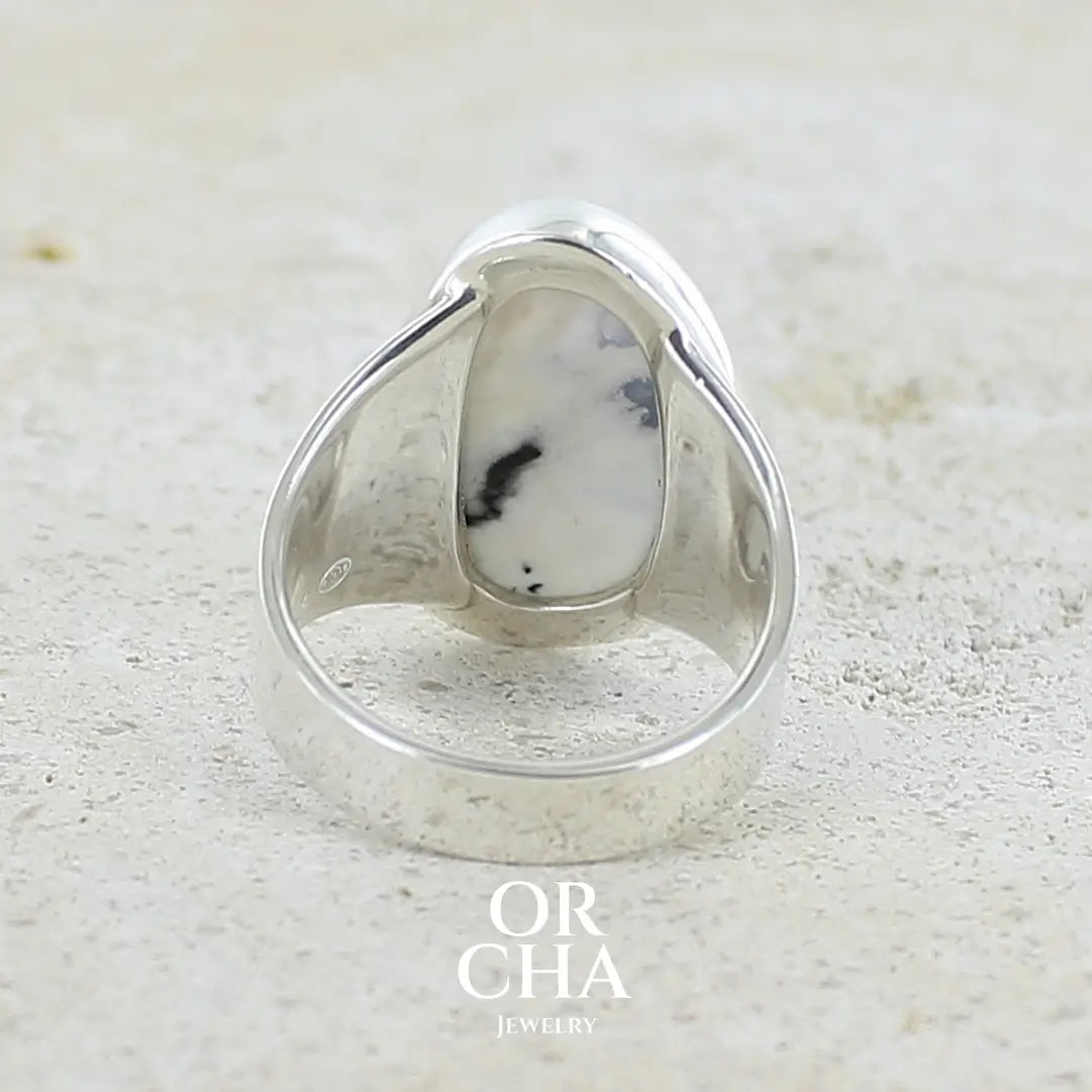 Vue de dos d'une bague pour femme en argent massif sertie d'un cabochon d'agate dendritique de couleur blanc pur et noir. Pierre opaque translucide à inclusions paysages de dendrites de manganèse noires contrastées. Bijou unique réalisée en taille 56 par Orchajewelry