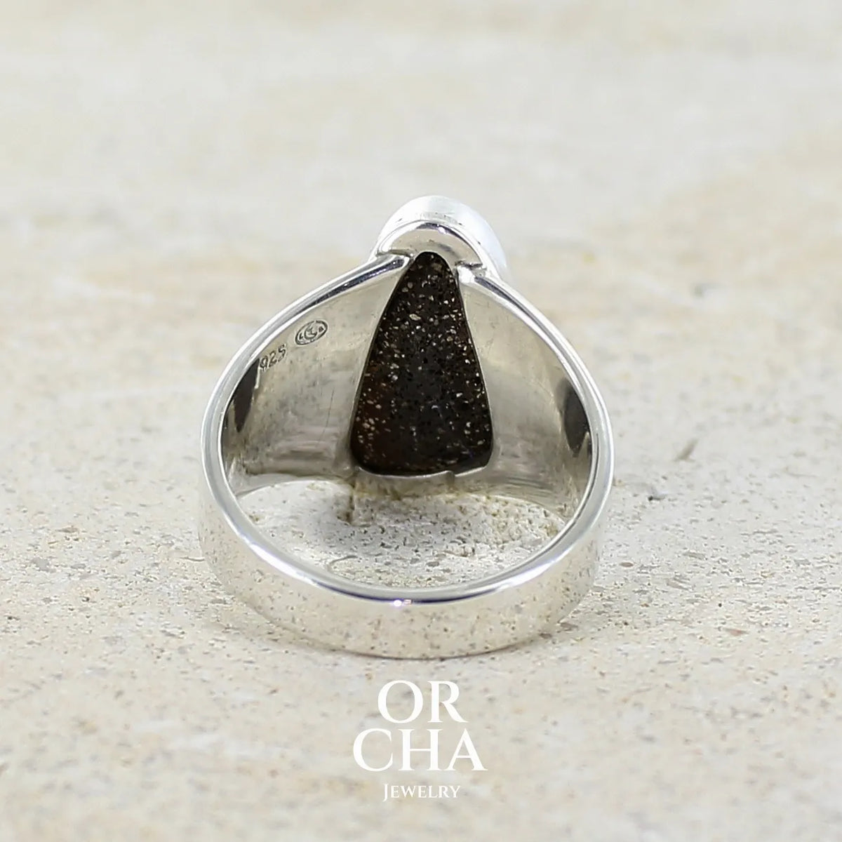 Vue de dos d'une bague pour femme en argent massif 925 sertie d'une opale boulder aux feux multicolores bleus violet et verts. Cabochon d'opale massive naturelle taillée en forme d'aile. Pierre de qualité opaque. Bijoux unique réalisé en taille 58 par Orcha Jewelry.