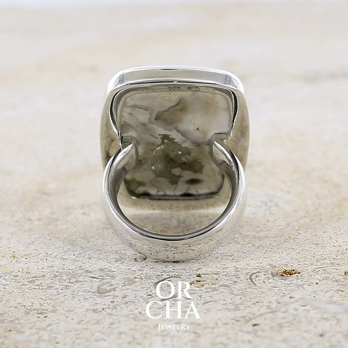 Vue de dos d'une bague pour femme en argent massif sertie d'un cabochon rectangulaire de jaspe océan de couleur blanc crème, gris, kaki et beige. Pierre de qualité opaque. Bijou unique réalisée en taille 54 par Orchajewelry