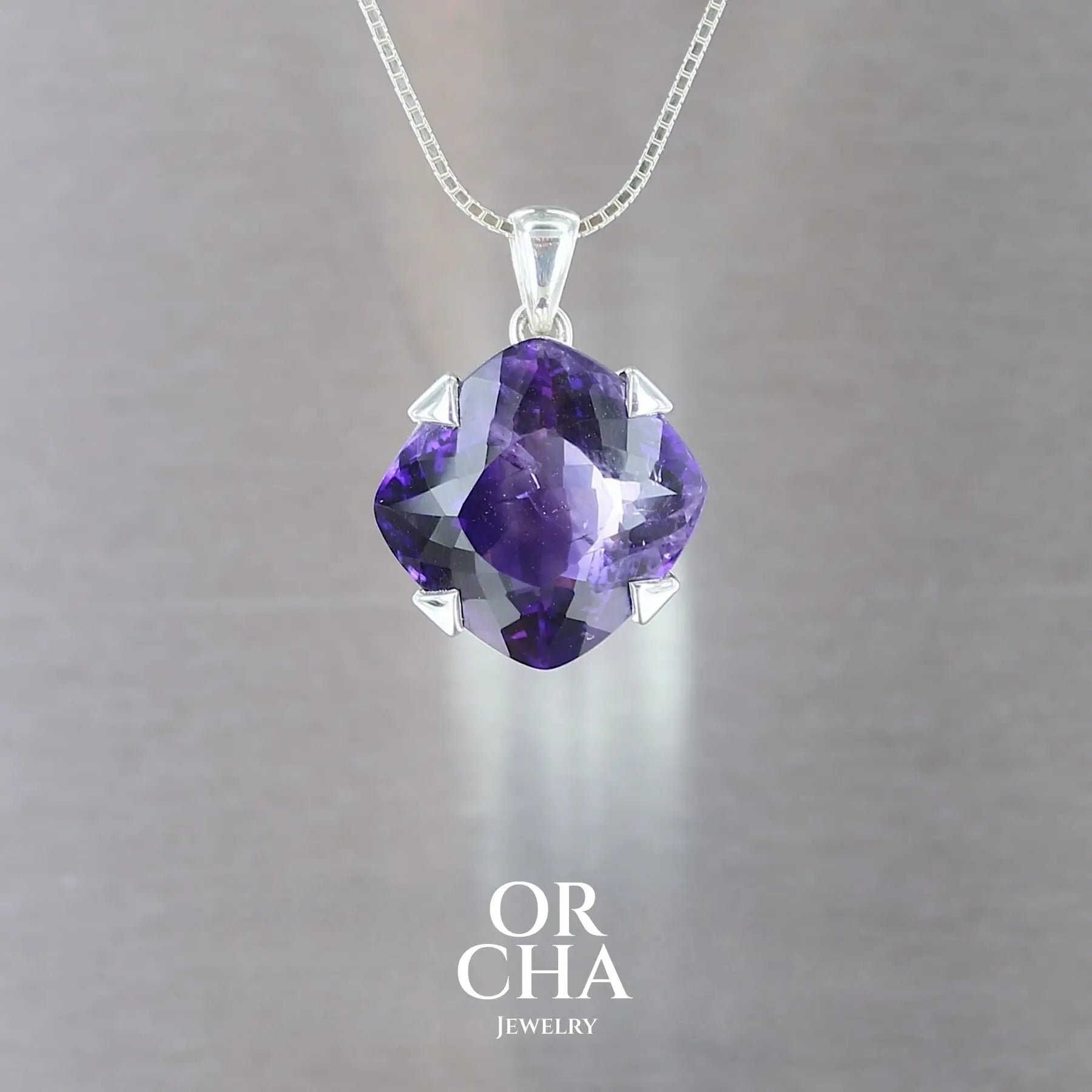 pendentif pour femme en argent massif serti d'une Améthyste de 26,8 carats de couleur violette intense. Pierre facettée naturelle transparente présentant des inclusions de rutiles argentés,  spécimen rare. Bijoux unique, éthique et durable présenté dans un coffret de notre marque, prêt à offrir. Livraison offerte, certificat d'authenticité, service client.