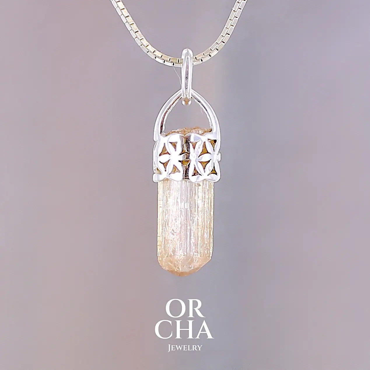 Pendentif cristal de topaze impériale en argent massif, sertissage filigrané de fleurs de vie. La pierre est  de couleur jaune arrangé pêche. Cristal brute, transparent, inclusions naturelles. Bijoux unique, éthique et durable présenté dans un coffret de notre marque, prêt à offrir. Livraison offerte, certificat d'authenticité, service client.
