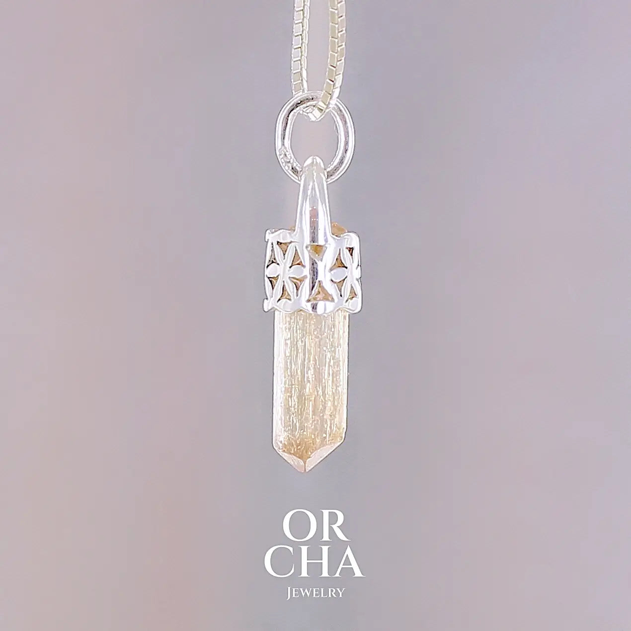 Pendentif cristal de topaze impériale en argent massif, sertissage filigrané de fleurs de vie. La pierre est  de couleur jaune arrangé pêche. Cristal brute, transparent, inclusions naturelles. Bijoux unique, éthique et durable présenté dans un coffret de notre marque, prêt à offrir. Livraison offerte, certificat d'authenticité, service client.