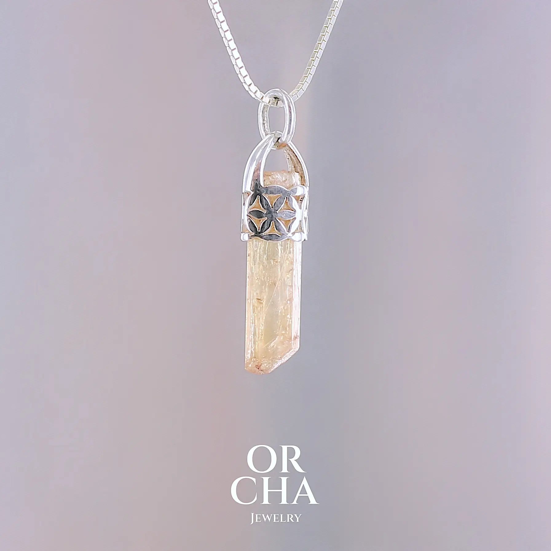 Pendentif fleur de vie en argent massif serti d'un cristal de topaze impériale de couleur jaune arrangé. Cristal brute mate, transparent, présentant des inclusions internes et en surface. Bijoux unique, éthique et durable présenté dans un coffret de notre marque, prêt à offrir. Livraison offerte, certificat d'authenticité, service client.
