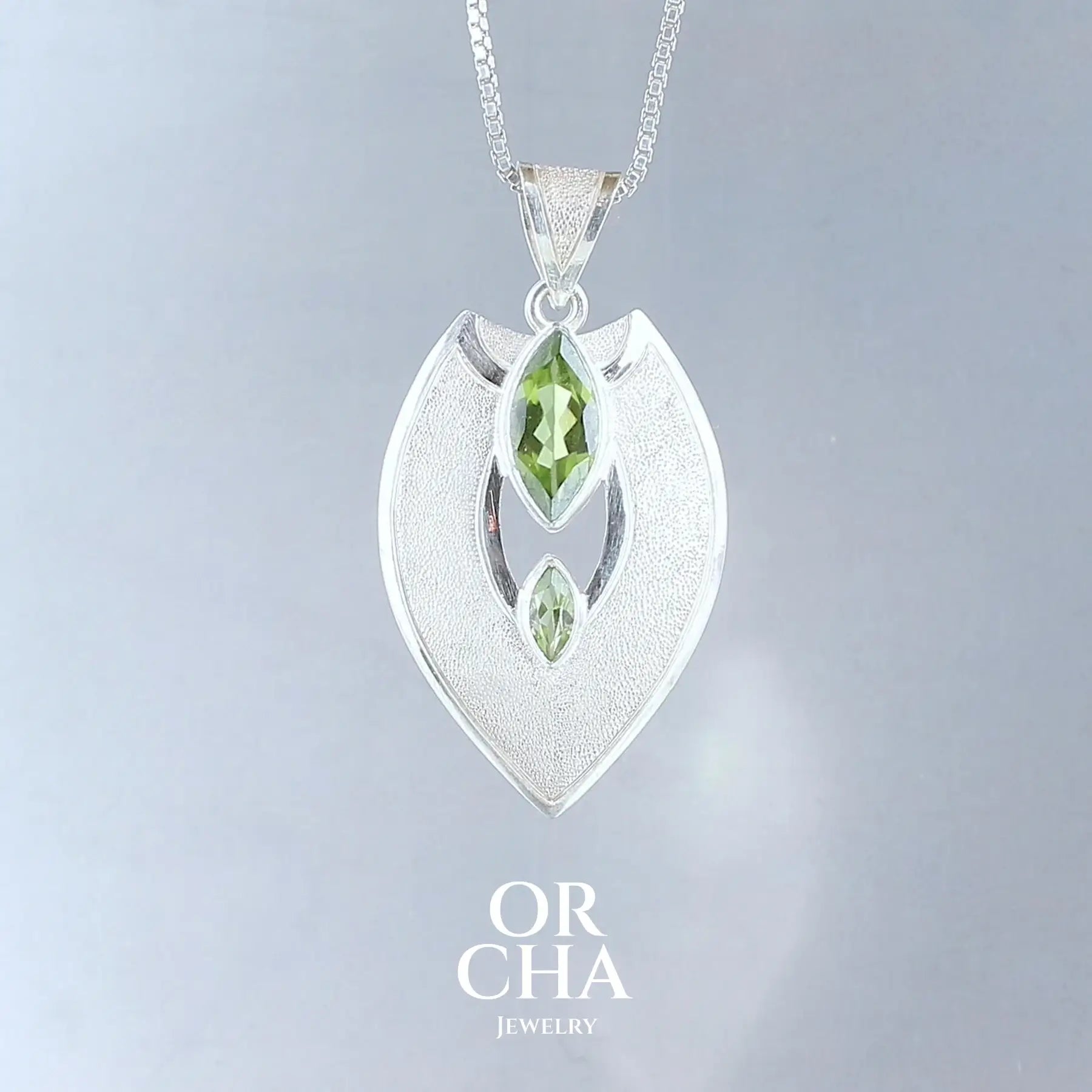 pendentif pour femme en argent massif serti d'une Péridots de couleur vert tendre Pierre facettée naturelle transparente présentant des inclusions. Bijoux unique, éthique et durable présenté dans un coffret de notre marque, prêt à offrir. Livraison offerte, certificat d'authenticité, service client.
