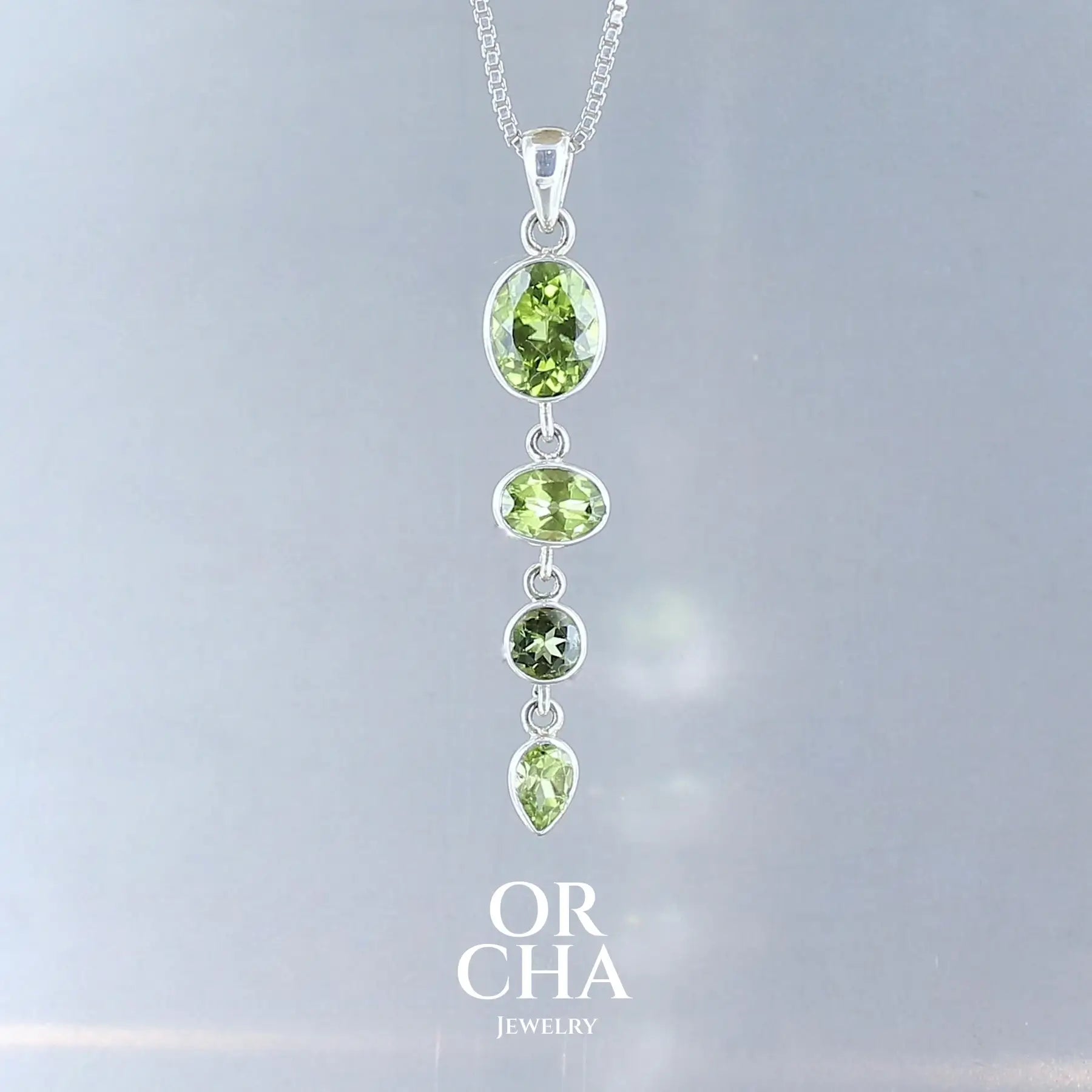 pendentif pour femme en argent massif serti d'une ligne de Peridots de couleur vert intense. Pierres facettées naturelles transparentes, propres à l'oeil. Bijoux unique, éthique et durable présenté dans un coffret de notre marque, prêt à offrir. Livraison offerte, certificat d'authenticité, service client.
