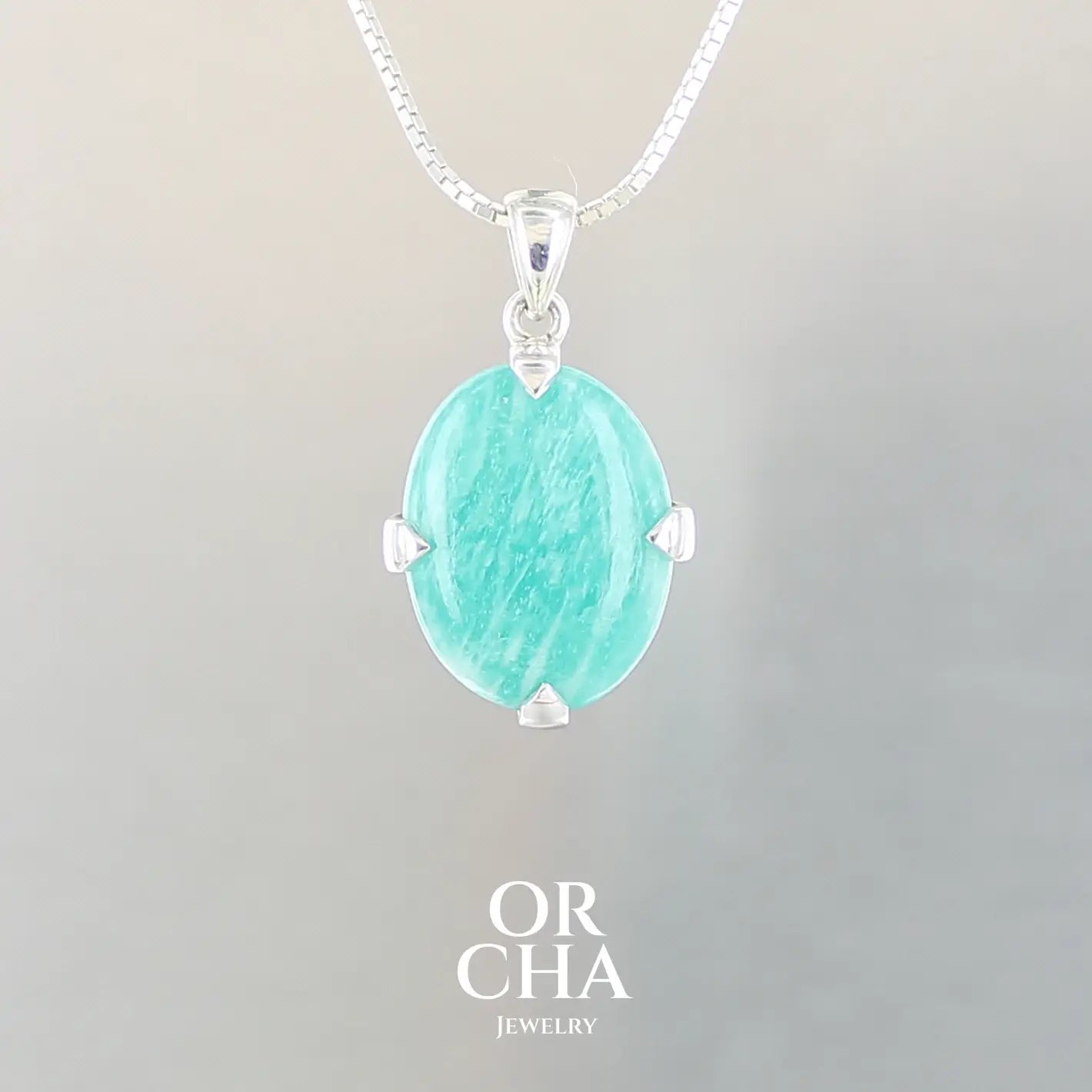 Pendentif pour femme en argent massif serti d'une Amazonite de couleur bleu intense. Pierre cabochon de forme ovale translucide présentant des inclusions. Bijoux unique, éthique et durable présenté dans un coffret de notre marque, prêt à offrir. Livraison offerte, certificat d'authenticité, service client.