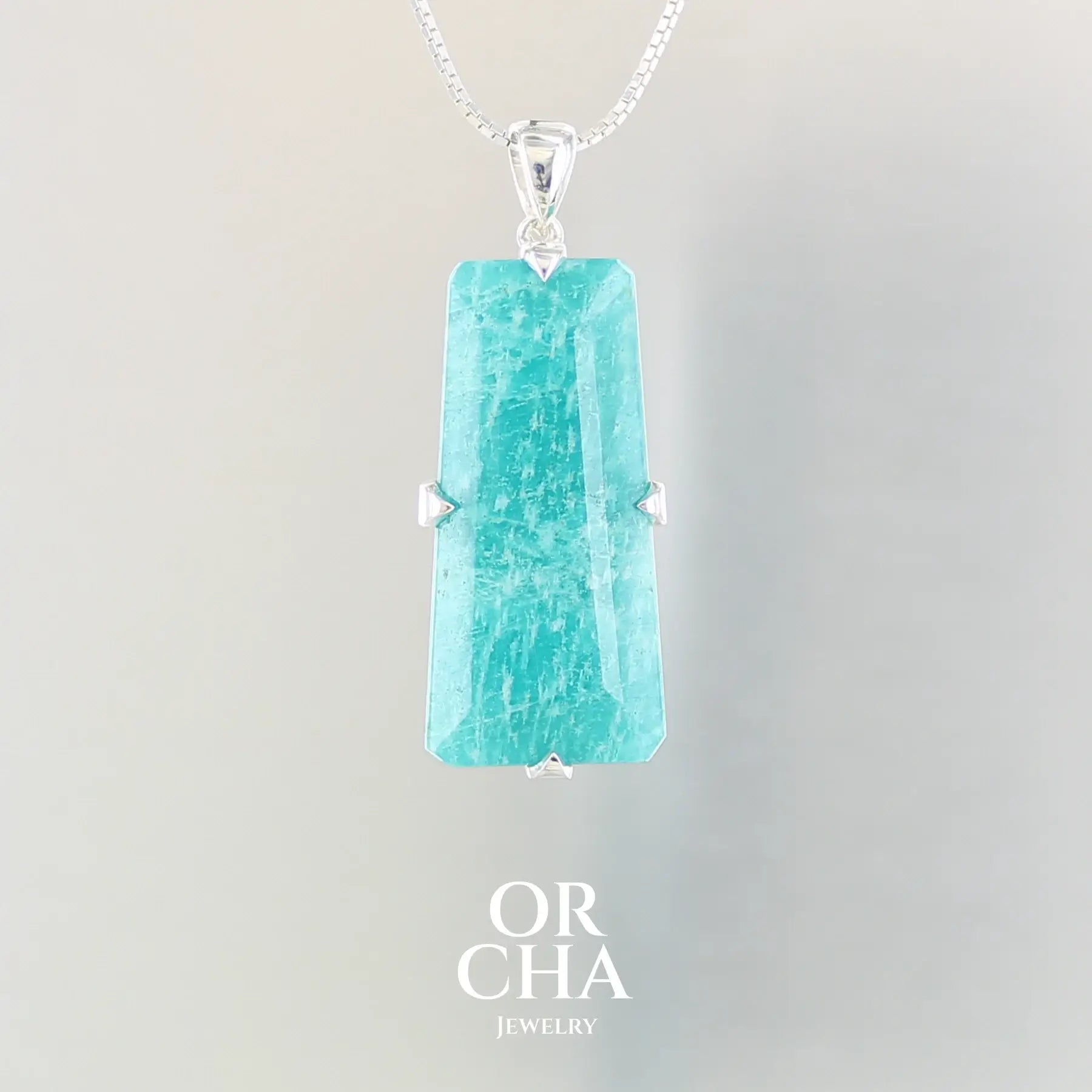 Grand pendentif pour femme en argent massif serti d'une Amazonite de couleur bleu intense. Pierre facettée de forme géométrique translucide présentant des inclusions. Bijoux unique, éthique et durable présenté dans un coffret de notre marque, prêt à offrir. Livraison offerte, certificat d'authenticité, service client