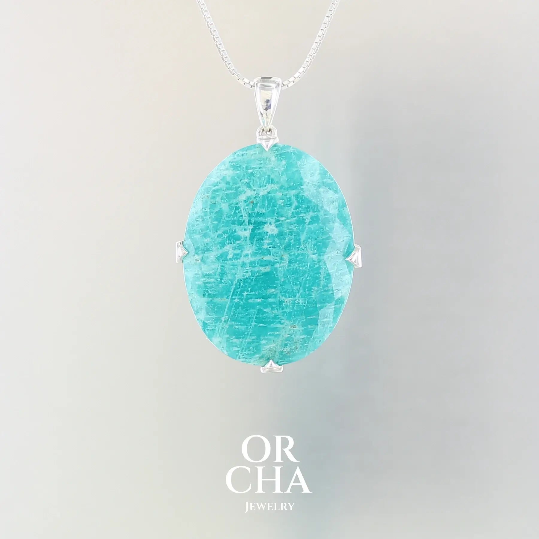 Grand pendentif pour femme en argent massif serti d'une Amazonite de couleur bleu intense. Pierre facettée de forme ovale translucide présentant des inclusions. Bijoux unique, éthique et durable présenté dans un coffret de notre marque, prêt à offrir. Livraison offerte, certificat d'authenticité, service client
