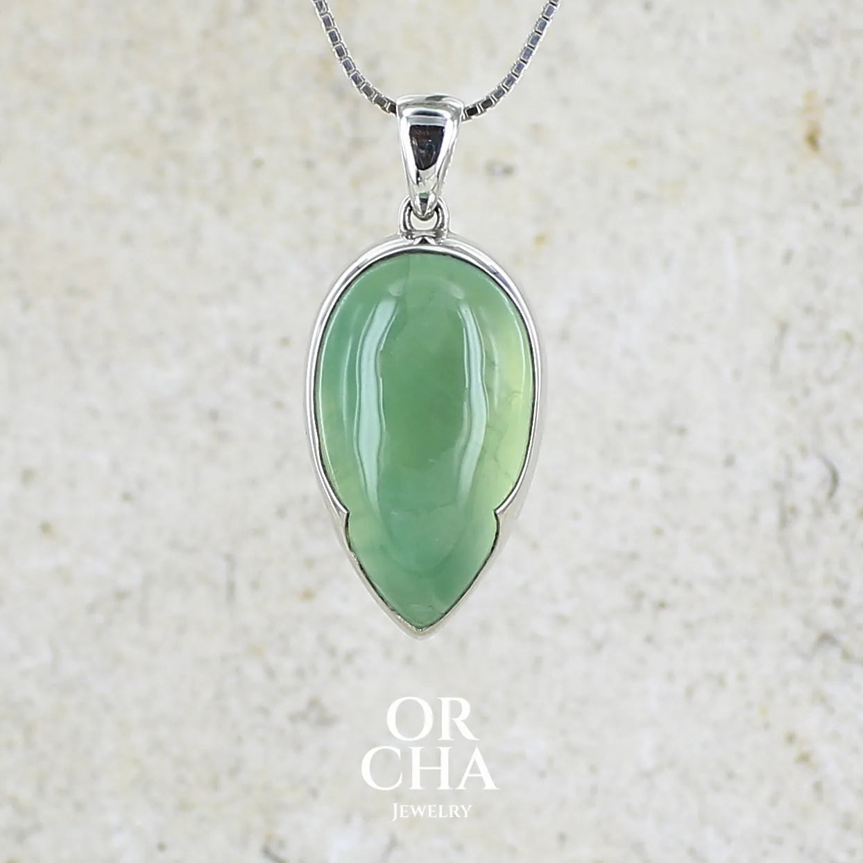 Pendentif pour femme en argent massif serti d'une préhnite de couleur vert jaune clair. Pierre naturelle taillée en cabochon en forme de goutte. Bijoux unique par orchajewelry.