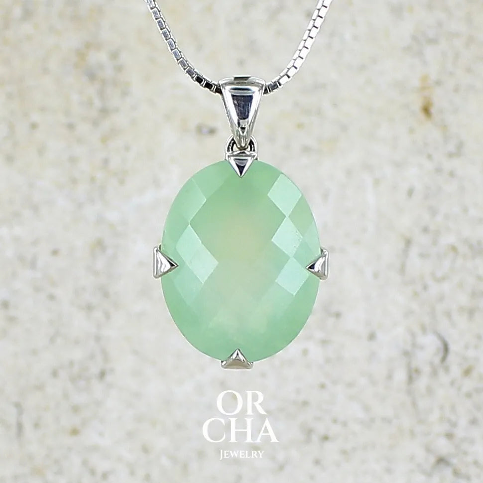 Pendentif ovale en argent massif, serti d'un cabochon facetté de préhnite de couleur verte jaune pastel. Pierre de qualité translucide comportant des inclusions. Bijoux unique par Orcha Jewelry