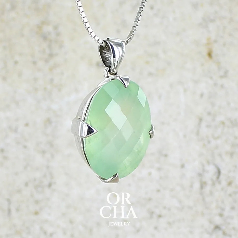 Pendentif ovale en argent massif, serti d'un cabochon facetté de préhnite de couleur verte jaune pastel. Pierre de qualité translucide comportant des inclusions. Bijoux unique par Orcha Jewelry