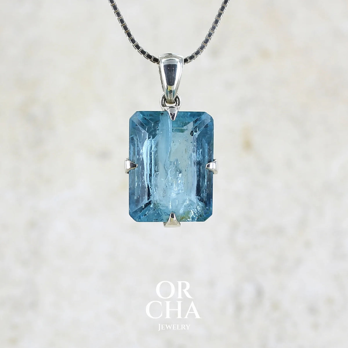 Pendentif unisexe en argent massif sertie d'une aigue marine taillée de 17 carats de couleur bleu foncé profond et intense, pierre transparente avec de grosses inclusions. Pierre naturelle facettée de forme rectangulaire. Bijoux unique réalisée par Orchajewelry