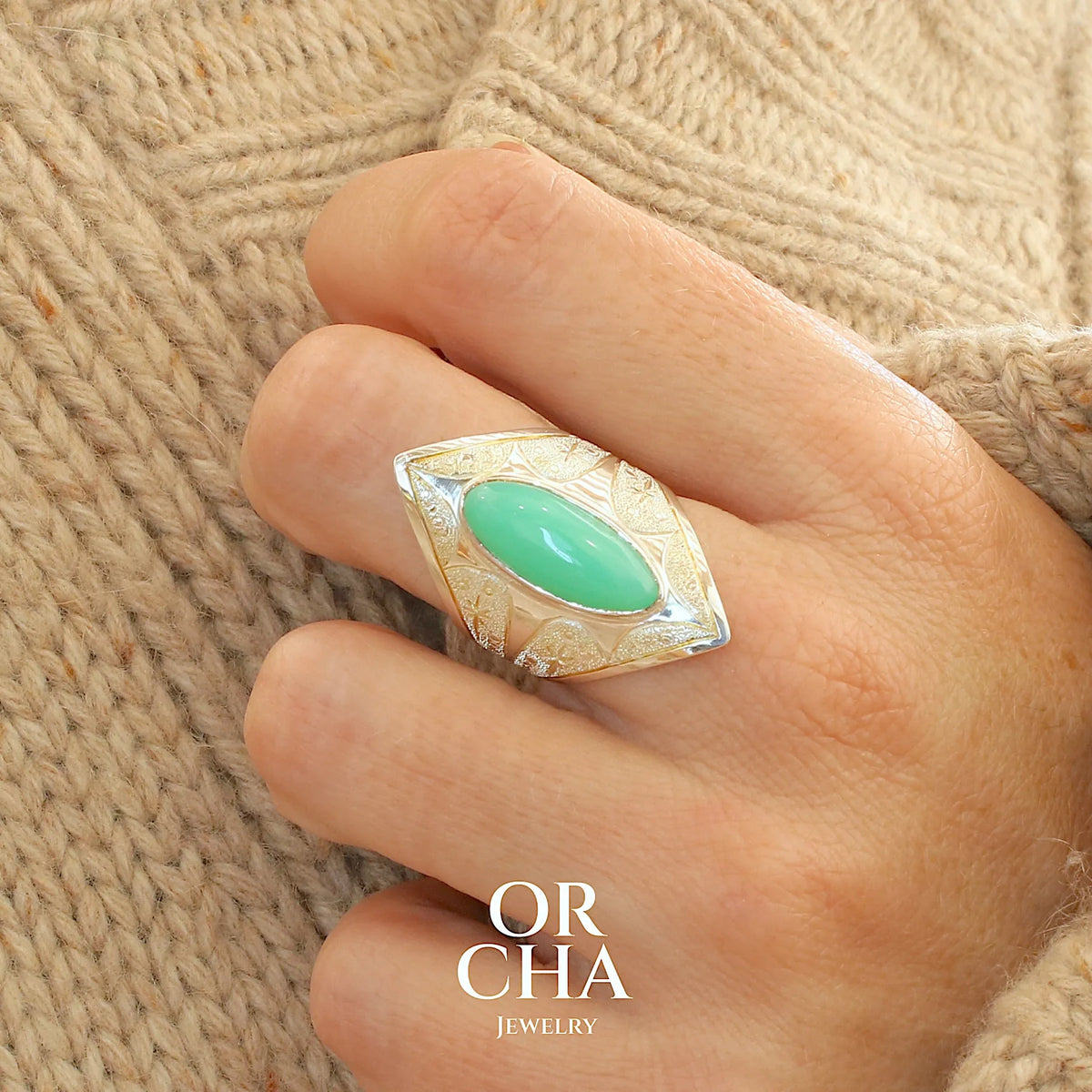 Bague marquise pour femme en argent massif sculptées d'étoiles et autres corps célestes sertie d'un cabochon de chrysoprase de couleur verte pastel. Pierre naturelle de qualité translucide taillée en ovale longiligne. Bague unique réalisée en taille 57 par Orcha jewelry