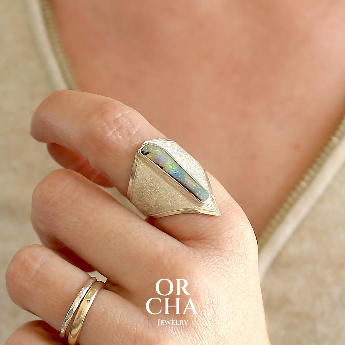 Bague plastron pour femme en argent massif 925 sertie d'une opale boulder aux feux multicolores. Cabochon d'opale massive naturelle, de qualité opaque. Bijoux unique réalisé en taille 59 par Orcha Jewelry.