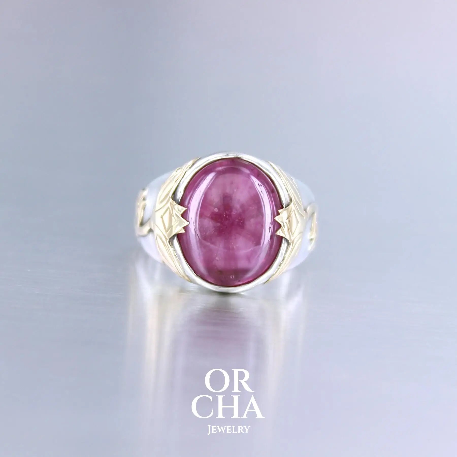 Bague chevalière pour femme en argent massif et or 18k où s'illustrent de chaque cotés de la bague des chardons. Cette bague est sertie d'un cabochon de rubis trapiche de couleur rouge rose. Pierre  translucide traitée au verre au plomb. Taille 60. Bijoux unique, éthique et durable présenté dans un coffret de notre marque, prêt à offrir. Livraison offerte, certificat d'authenticité, service client.