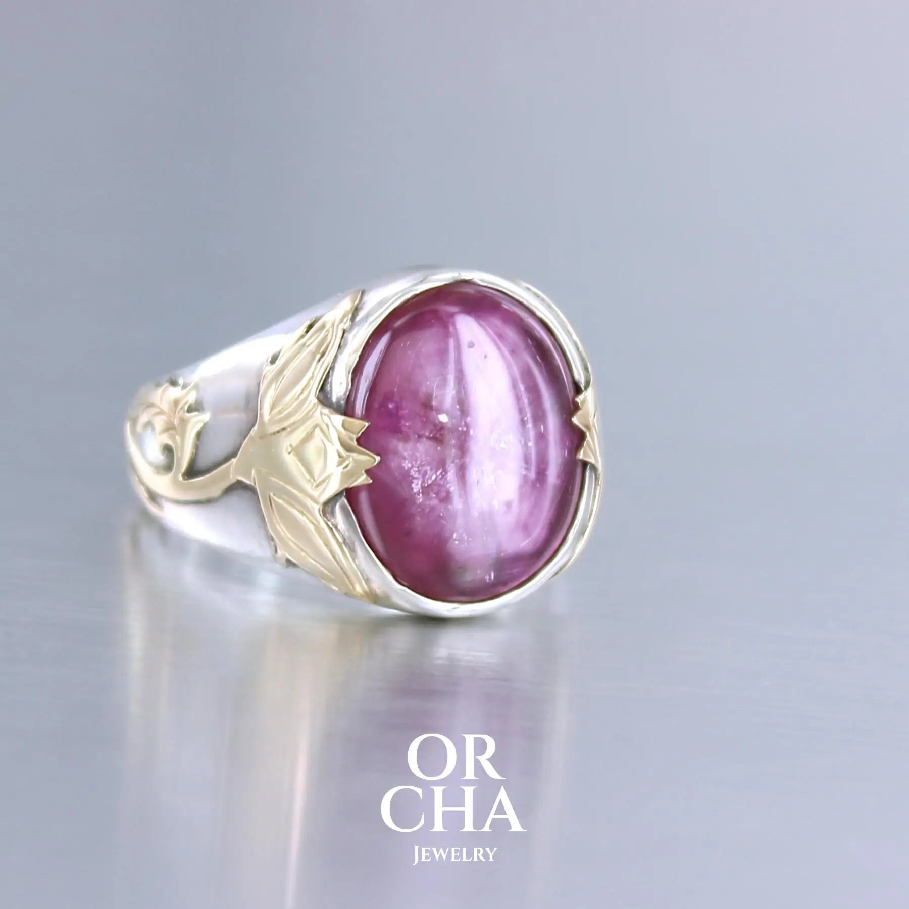 Bague chevalière pour femme en argent massif et or 18k où s'illustrent de chaque cotés de la bague des chardons. Cette bague est sertie d'un cabochon de rubis trapiche de couleur rouge rose. Pierre  translucide traitée au verre au plomb. Taille 60. Bijoux unique, éthique et durable présenté dans un coffret de notre marque, prêt à offrir. Livraison offerte, certificat d'authenticité, service client.