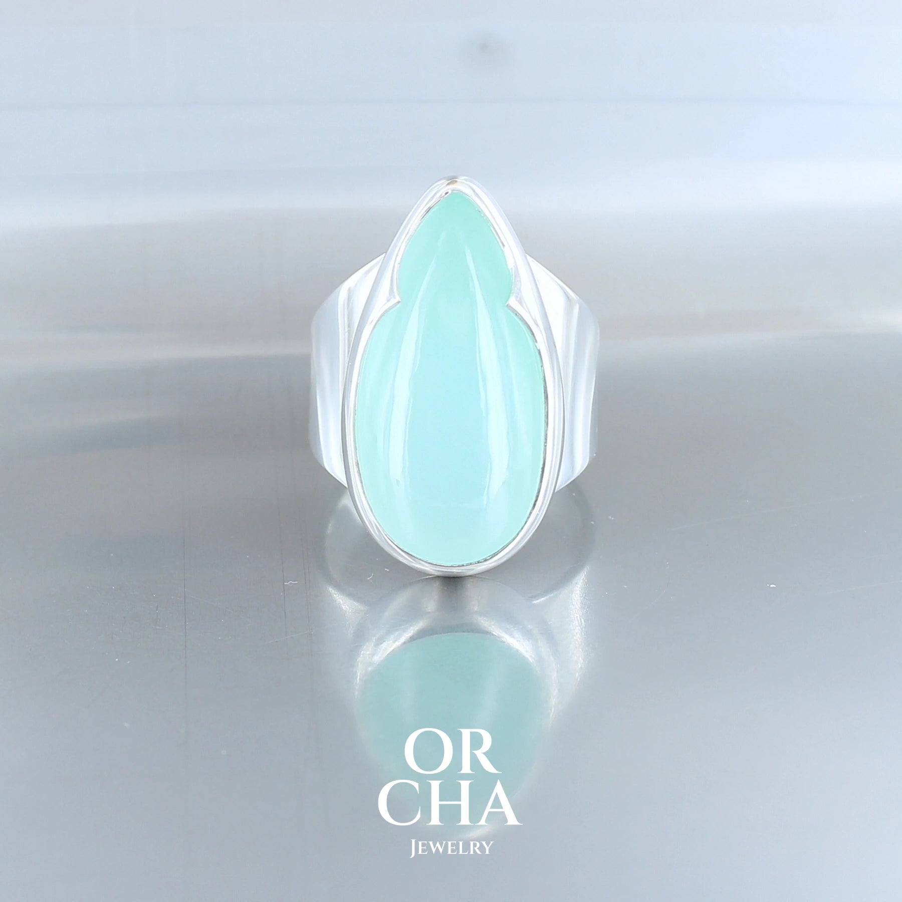 Grande bague de créateur, pour femme, en argent massif sertie d'un cabochon de Chrysoprase de qualité AAA à la couleur verte bleutée lumineuse et pétillante. Bague de créateur fabriquée à la main en taille 58