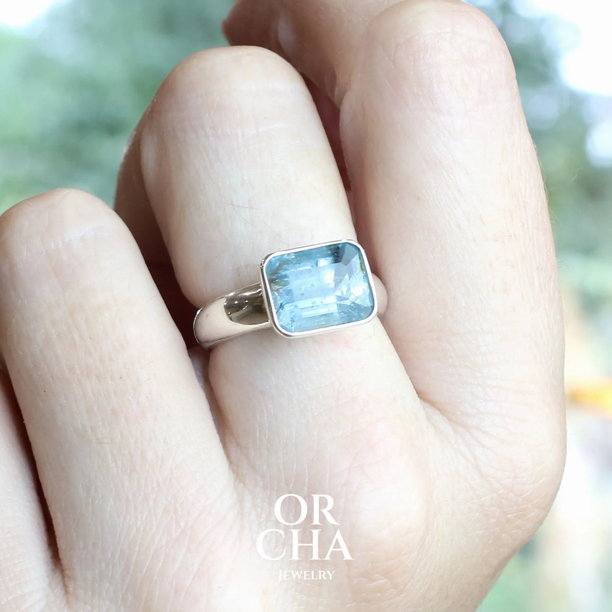 Bague pour femme en argent massif sertie d'une aigue marine taillée de 4 carats de couleur bleue foncé profonde  intense et lumineuse, pierre transparente avec inclusions. Pierre naturelle facettée de forme rectangulaire. Bijoux unique réalisée en taille 56 par Orchajewelry 
