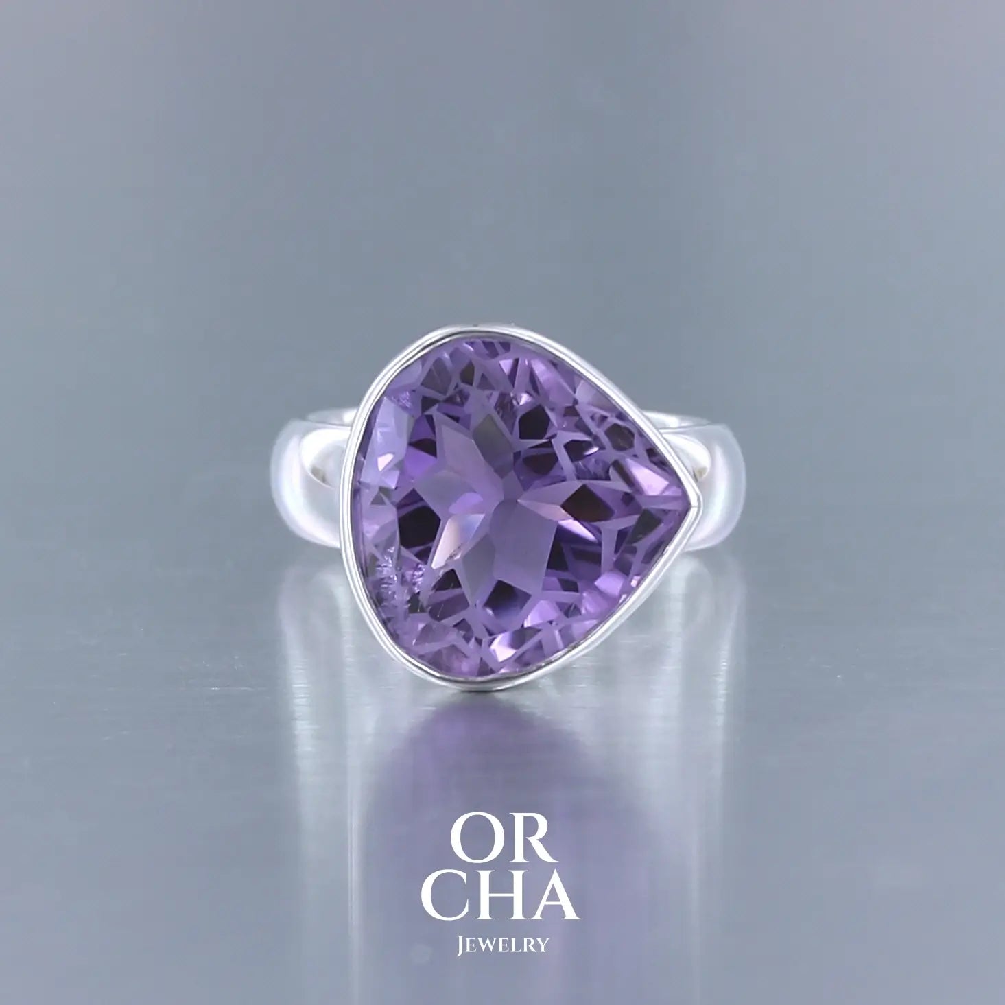Bague cocktail pour femme en argent massif sertie d'une Améthyste. Pierre facettée en forme de goutte de qualité transparente, propre à l'oeil. Pierre naturelle de couleur violette clair gravée de motifs géométriques de fleur de vie. Tailles 60. Bijoux unique, éthique et durable présenté dans un coffret de notre marque, prêt à offrir. Livraison offerte, certificat d'authenticité, service client.
