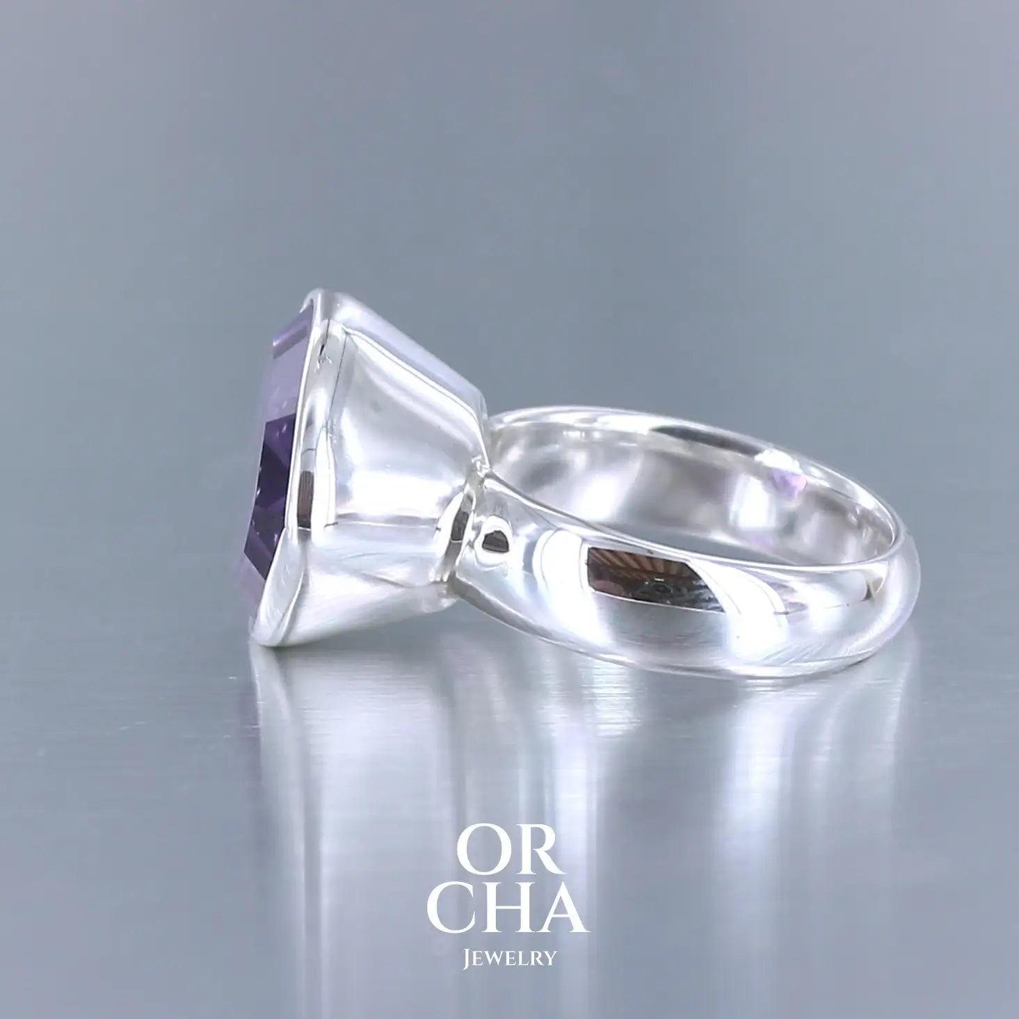 Bague cocktail pour femme en argent massif sertie d'une Améthyste. Pierre facettée en forme de goutte de qualité transparente, propre à l'oeil. Pierre naturelle de couleur violette clair gravée de motifs géométriques de fleur de vie. Tailles 60. Bijoux unique, éthique et durable présenté dans un coffret de notre marque, prêt à offrir. Livraison offerte, certificat d'authenticité, service client.