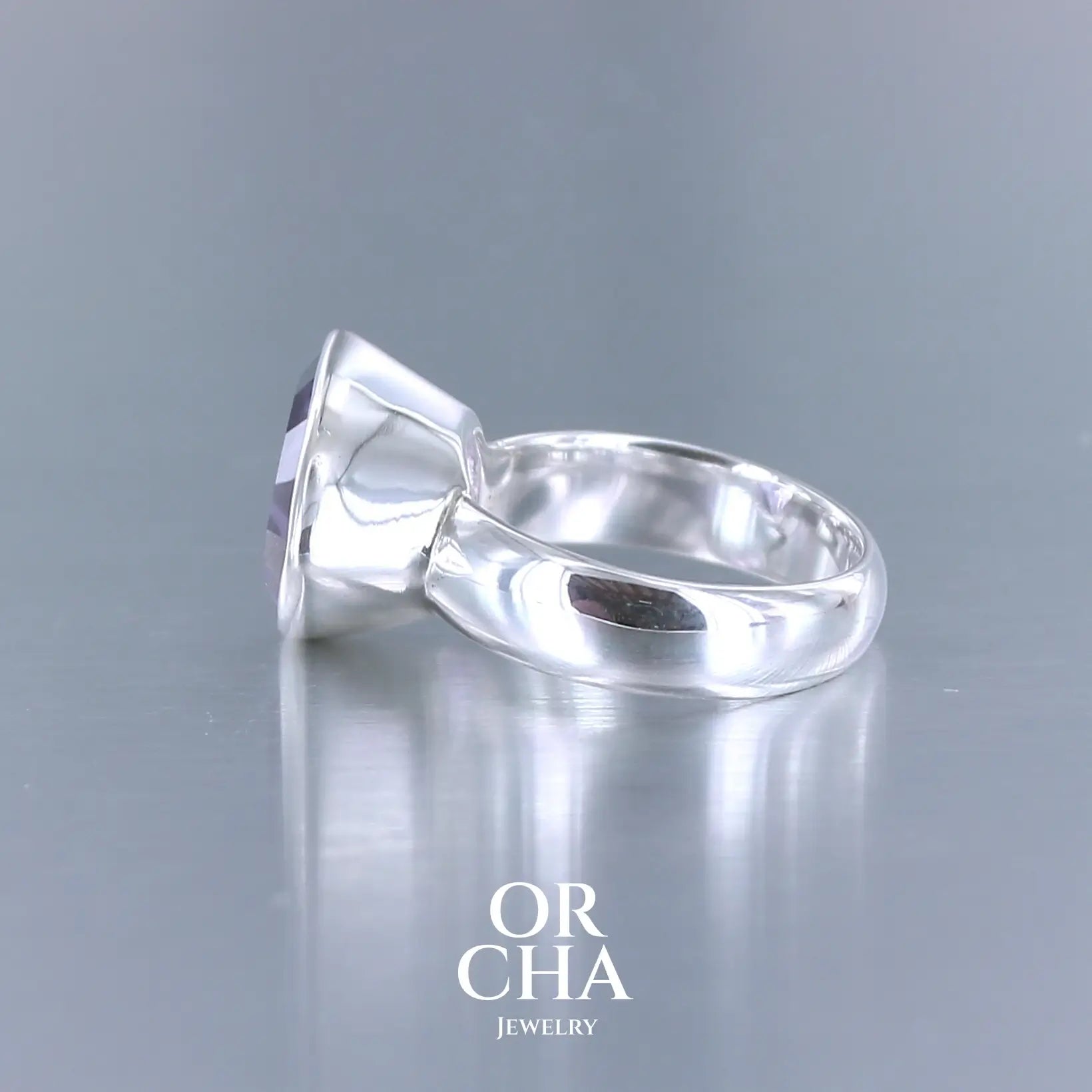 Bague cocktail pour femme en argent massif sertie d'une Améthyste. Pierre taillée trillion de qualité transparente, propre à l'oeil. Pierre naturelle de couleur violette clair gravée de motifs géométriques de fleur de vie. Tailles 58. Bijoux unique, éthique et durable présenté dans un coffret de notre marque, prêt à offrir. Livraison offerte, certificat d'authenticité, service client.
