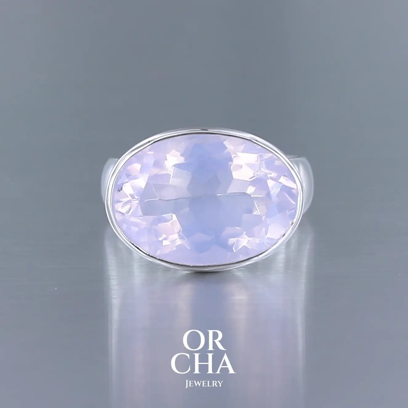 Bague cocktail pour femme en argent massif sertie d'un Quartz lavande. Pierre facettée de forme ovale de qualité transparente, propre à l'oeil. Pierre naturelle de couleur violette pastel teintée de rose avec de légers reflets opalescents. Bague réalisée en taille 56 . Bijoux unique, éthique et durable présenté dans un coffret de notre marque, prêt à offrir. Livraison offerte, certificat d'authenticité, service client.

