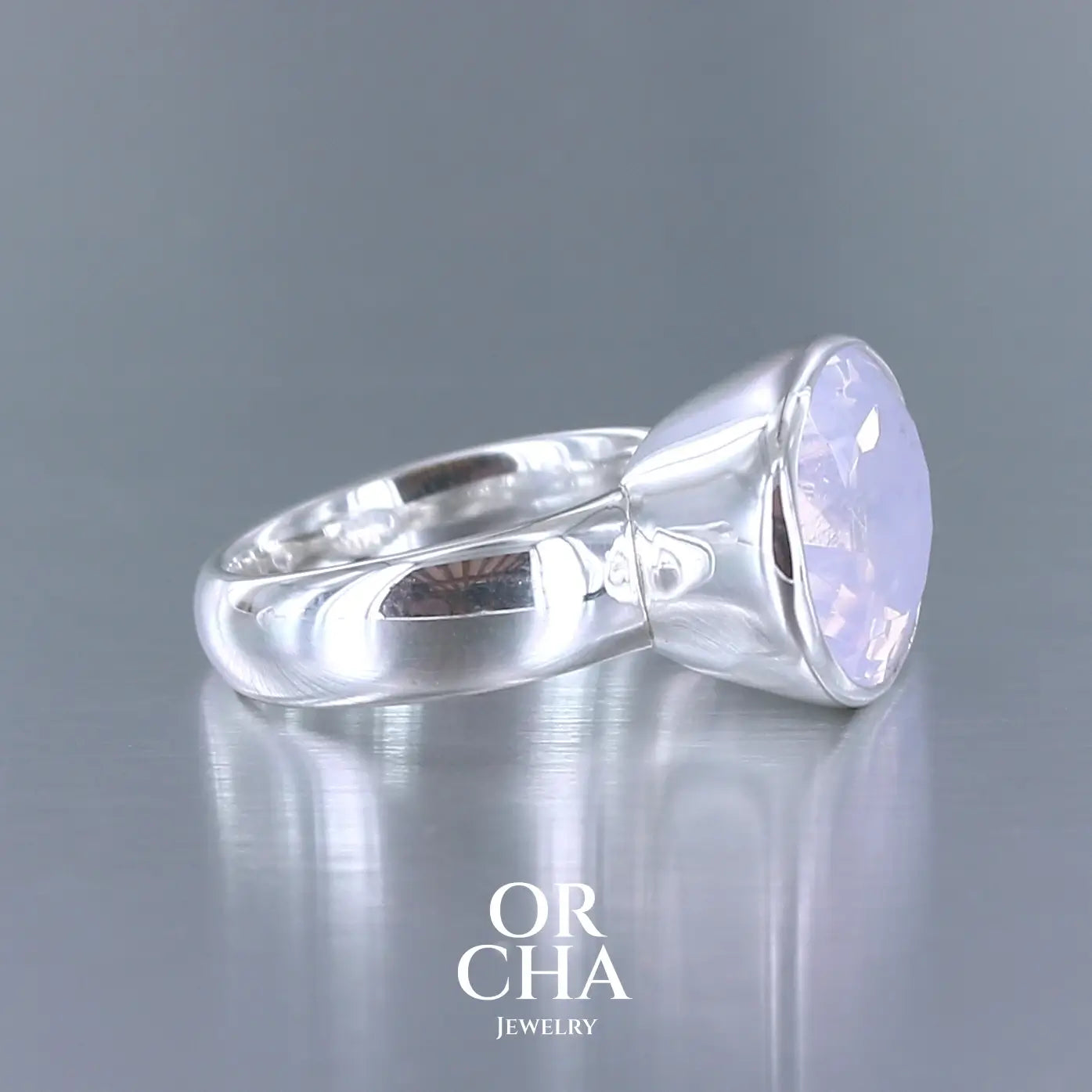 Bague cocktail pour femme en argent massif sertie d'un Quartz lavande. Pierre facettée de forme ovale de qualité transparente, propre à l'oeil. Pierre naturelle de couleur violette pastel teintée de rose avec de légers reflets opalescents. Bague réalisée en taille 56 . Bijoux unique, éthique et durable présenté dans un coffret de notre marque, prêt à offrir. Livraison offerte, certificat d'authenticité, service client.