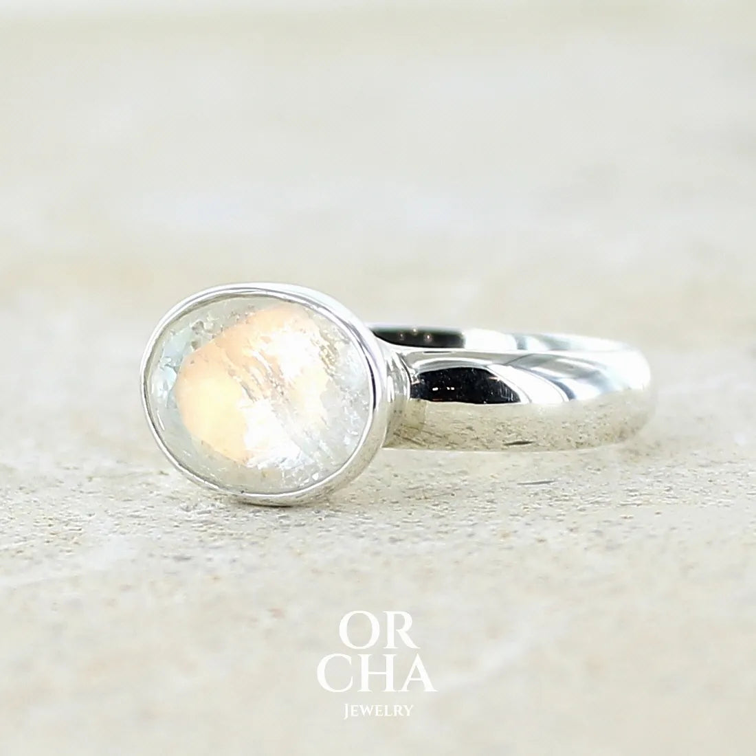 Bague cocktail pour femme en argent massif 925 sertie d'une pierre de lune de Madagascar arc-en-ciel taillée de 3,58 carats. Pierre incolore aux reflets bleutés et arc-en-ciel. Pierre transparente avec inclusions. Bijoux unique réalisé en taille 56 par Orchajewelry