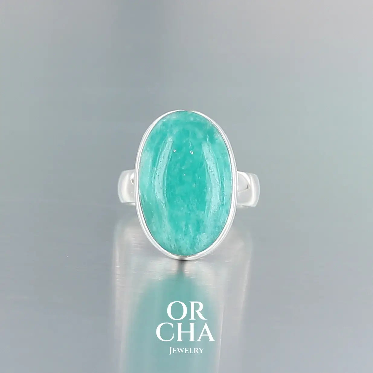 Bague pour femme en argent massif sertie d'une Amazonite. Pierre cabochon de forma ovale, pierre naturelle de couleur bleu vert présentant de légère marbrures blanches. Qualité  translucide. Taille 52. Bijoux unique, éthique et durable présenté dans un coffret de notre marque, prêt à offrir. Livraison offerte, certificat d'authenticité, service client