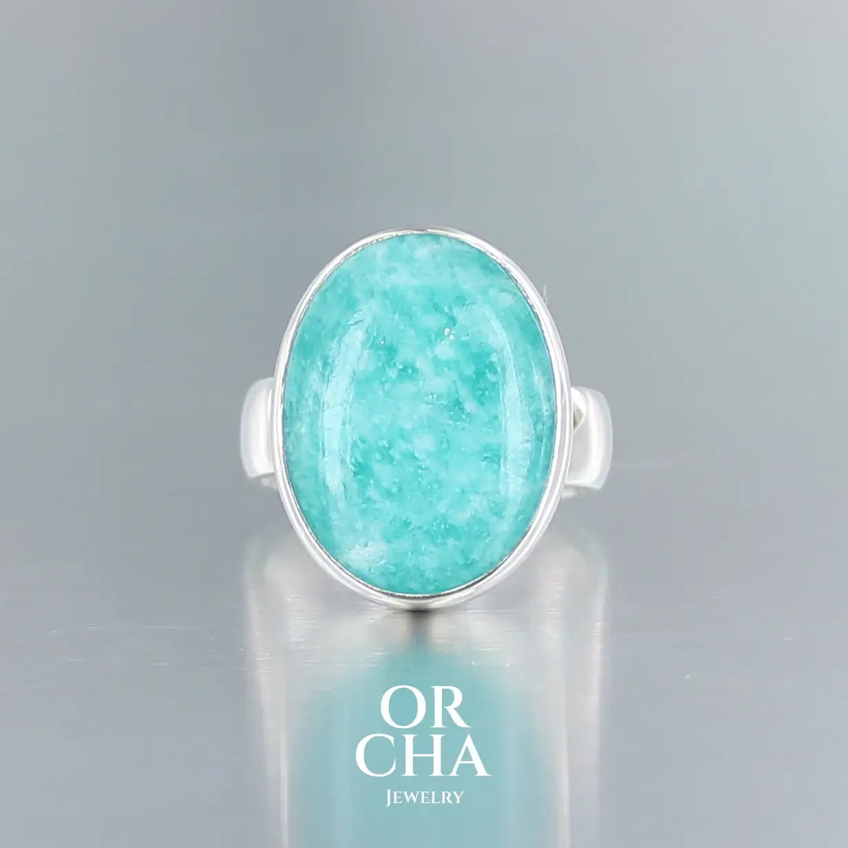 Bague pour femme en argent massif sertie d'une Amazonite. Pierre cabochon naturelle opaque de couleur bleu vert présentant des marbrures blanches. Taille 58. Bijoux unique, éthique et durable présenté dans un coffret de notre marque, prêt à offrir. Livraison offerte, certificat d'authenticité, service client.