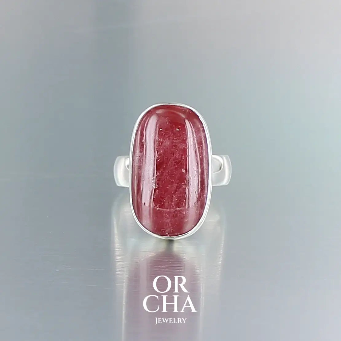 Bague pour femme en argent massif sertie d'une Rhodonite. Pierre cabochon de forme rectangulaire, pierre naturelle de couleur rouge coquelicot. Pierre fine de qualité  opaque à translucide présentant des inclusions. Taille 58. Bijoux unique, éthique et durable présenté dans un coffret de notre marque, prêt à offrir. Livraison offerte, certificat d'authenticité, service client.