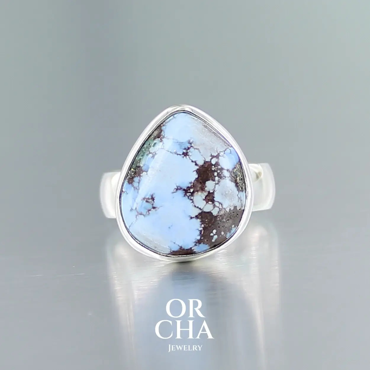 Bague pour femme en argent massif sertie d'une Turquoise Golden Hill. Pierre cabochon de forme fantaisiste, pierre naturelle aux nuances de bleus . Qualité  opaque, pierre non stabilisée. Taille 55. Bijoux unique, éthique et durable présenté dans un coffret de notre marque, prêt à offrir. Livraison offerte, certificat d'authenticité, service client.
