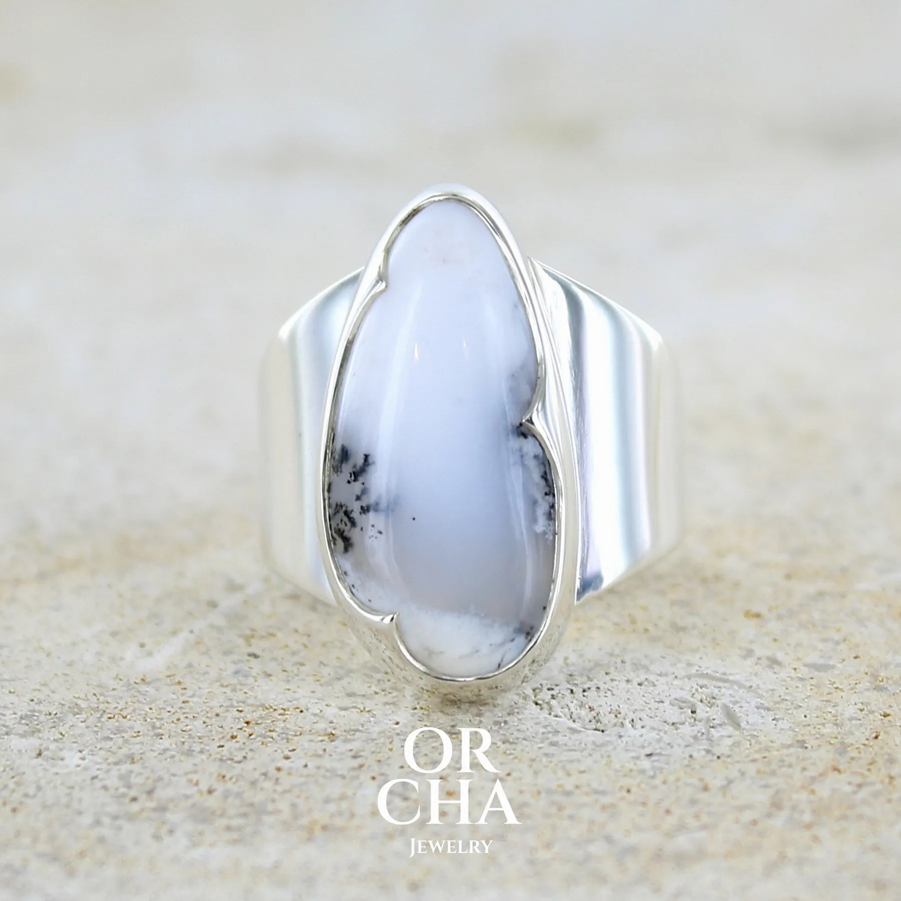Bague pour femme en argent massif sertie d'un cabochon ovale d'agate dendritique de couleur blanc pur et noir. Pierre opaque translucide à inclusions paysages de dendrites de manganèse noires contrastées. Bijou unique réalisée en taille 60 par Orchajewelry
