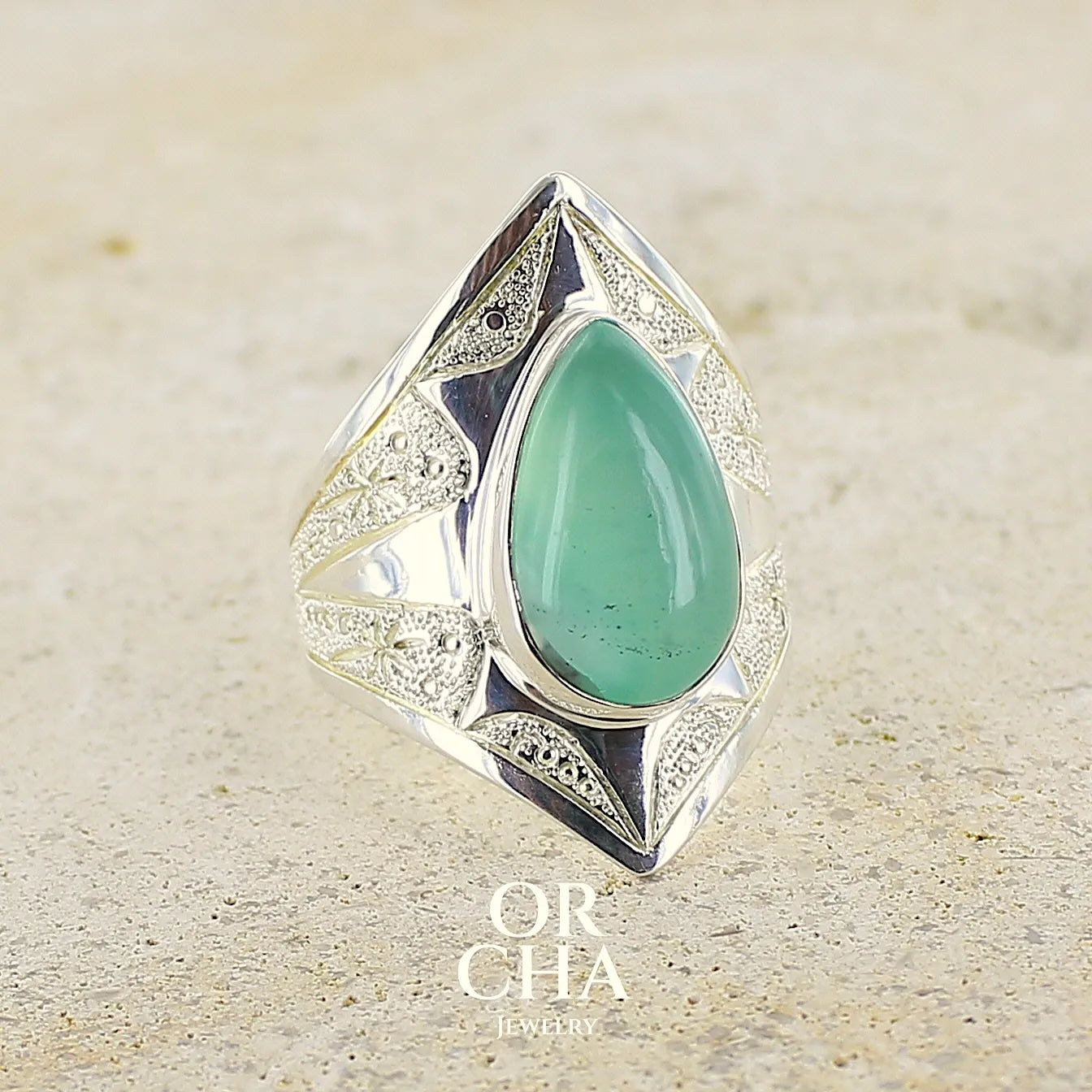 Bague étoile pour femme en argent massif, sertie d'un cabochon de calcédoine bleue verte. Pierre taillée de en forme de goutte. Pierre translucide. bijou unique réalisée en taille 59 par Orcha Jewelry