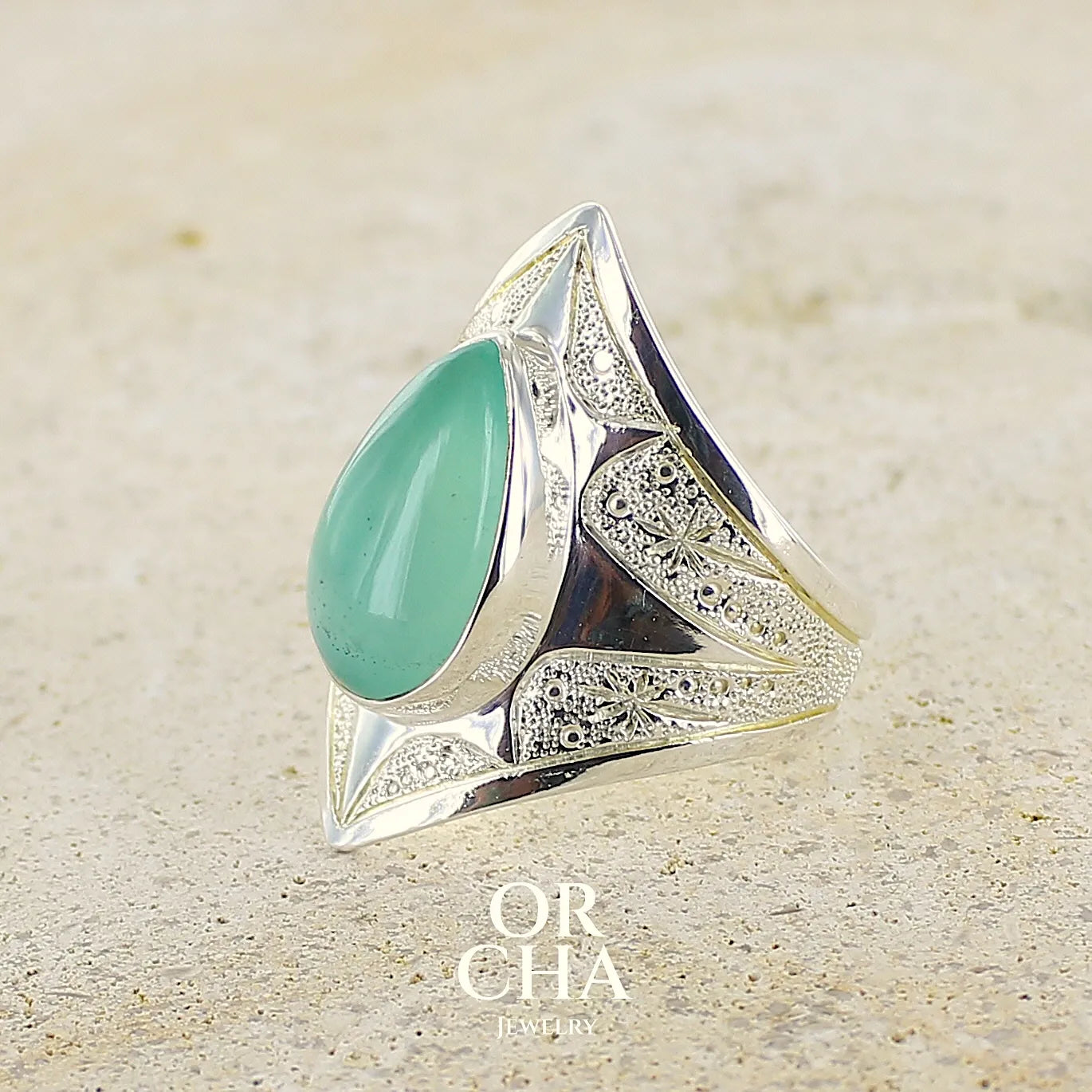 Bague étoile pour femme en argent massif, sertie d'un cabochon de calcédoine bleue verte. Pierre taillée de en forme de goutte. Pierre translucide. bijou unique réalisée en taille 59 par Orcha Jewelry