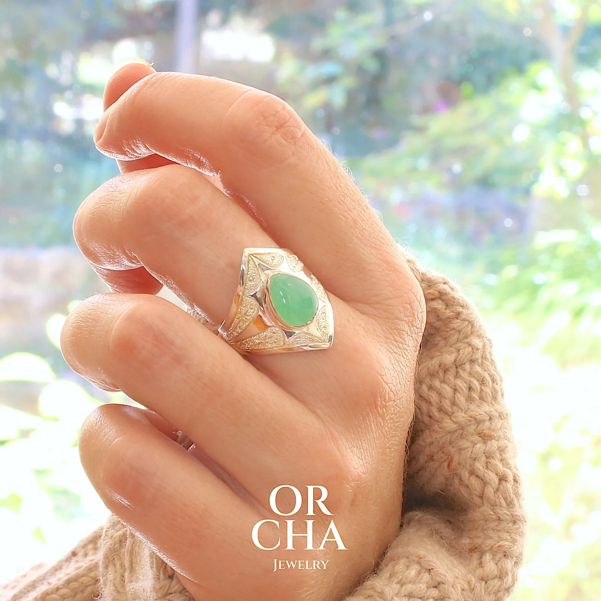 Bague étoile pour femme en argent massif sculptées d'étoiles et autres corps célestes sertie d'un cabochon de chrysoprase de couleur verte pastel. Pierre naturelle de qualité translucide taillée goutte. Bague unique réalisée en taille 57 par Orcha jewelry