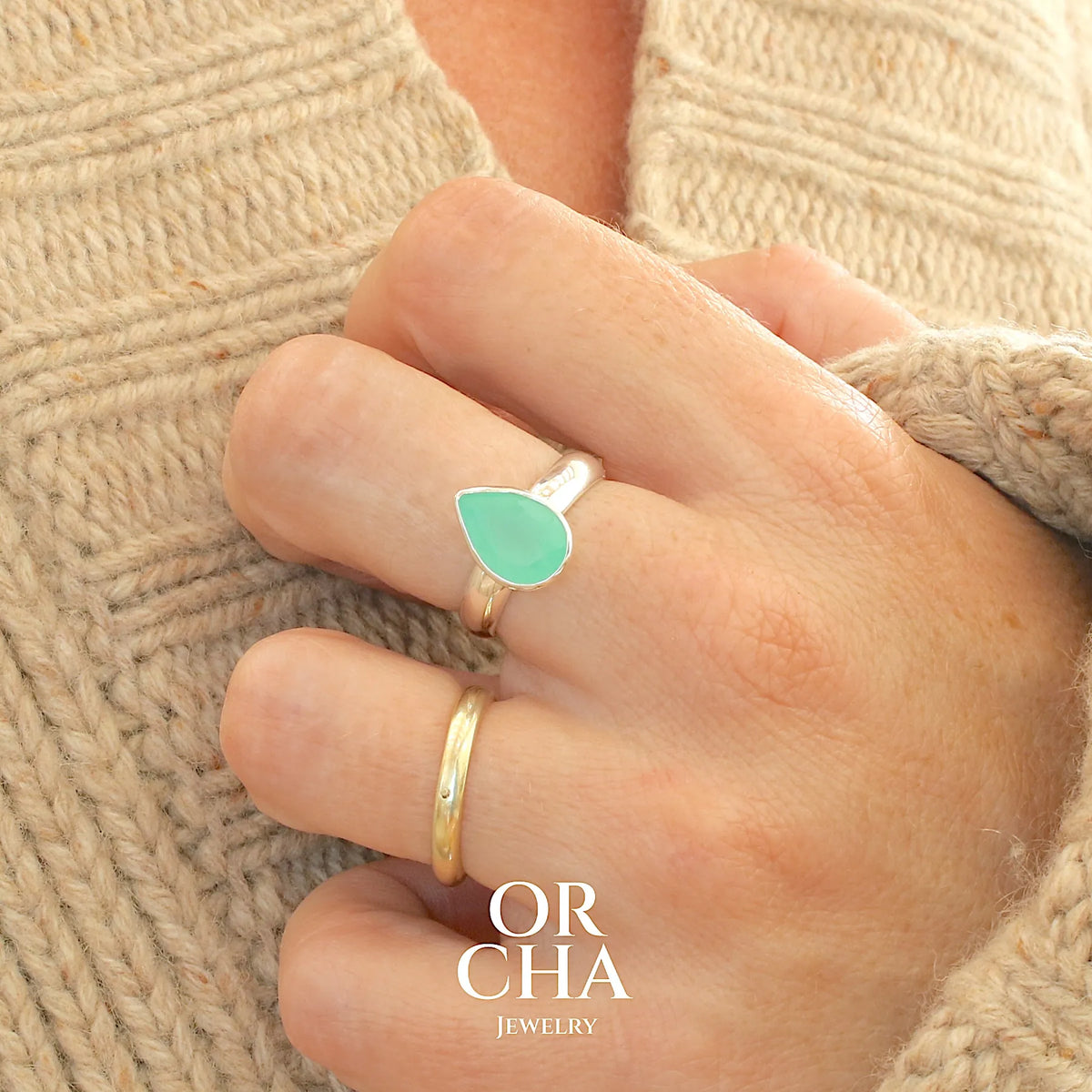 Bague pour femme en argent massif sertie d'un cabochon de chrysoprase de couleur vert émeraude pastel. Pierre translucide taillée en forme de goutte. Bijou unique réalisé en taille 56 par Orcha Jewelry