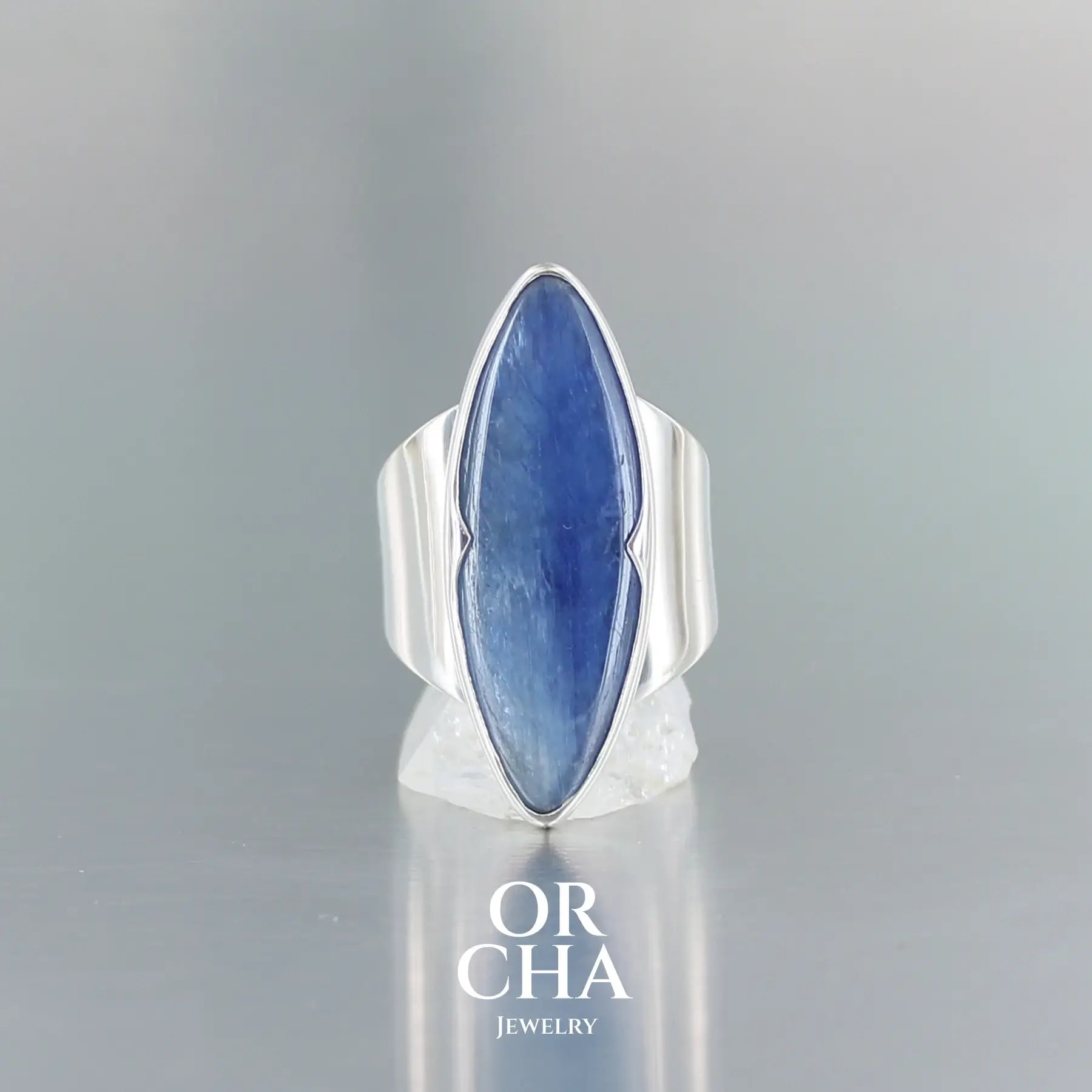 Bague marquise contemporaine pour femme en argent massif sertie d'une cyanite. Pierre cabochon transparente naturelle de couleur bleu jeans à reflet nacré. Taille 56. Bijoux unique, éthique et durable présenté dans un coffret de notre marque, prêt à offrir. Livraison offerte, certificat d'authenticité, service client.
