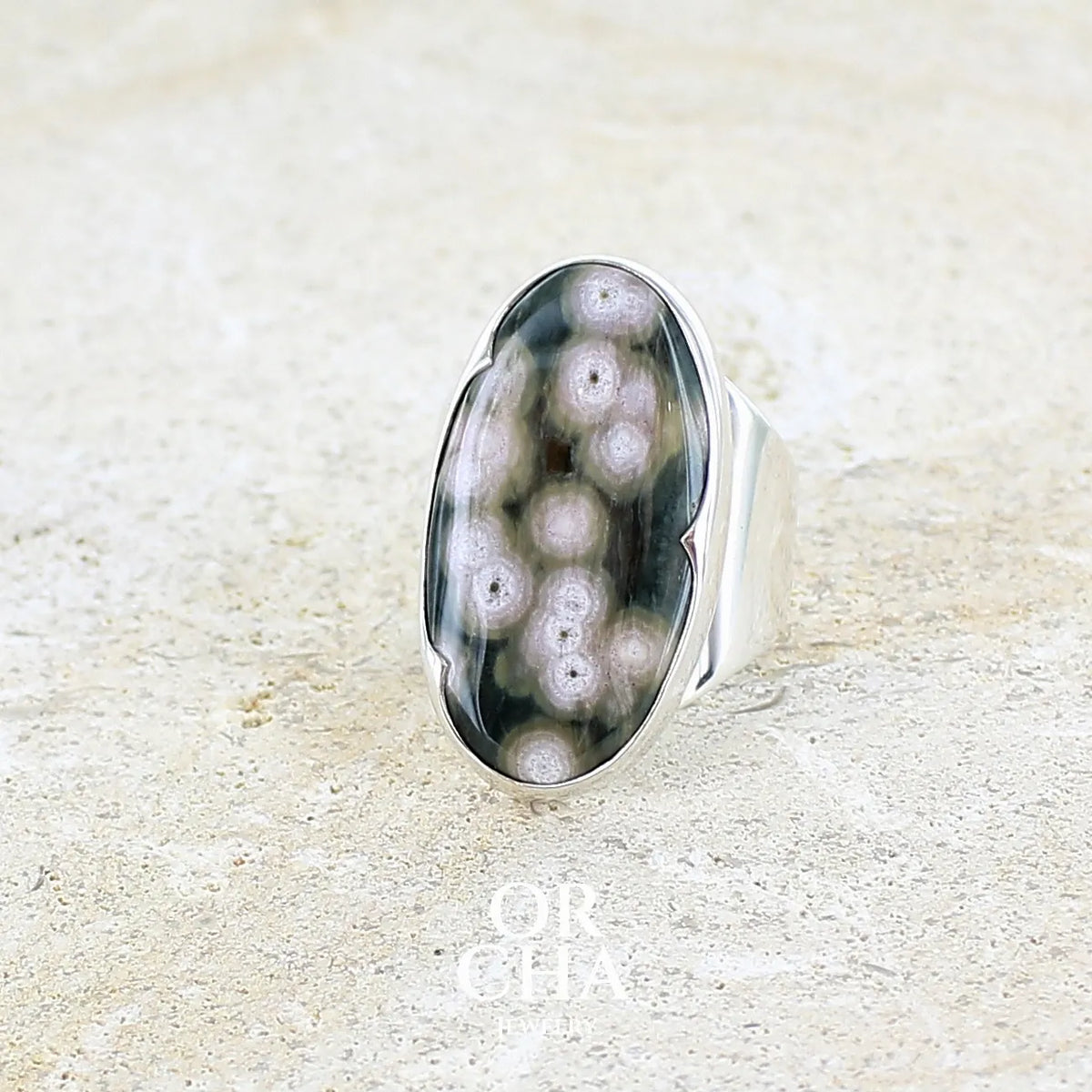Bague pour femme en argent massif sertie d'un cabochon ovale de jaspe orbiculaire de couleur vert kaki, blanc et rosé. Pierre de qualité opaque. Bijou unique réalisée en taille 58 par Orchajewelry