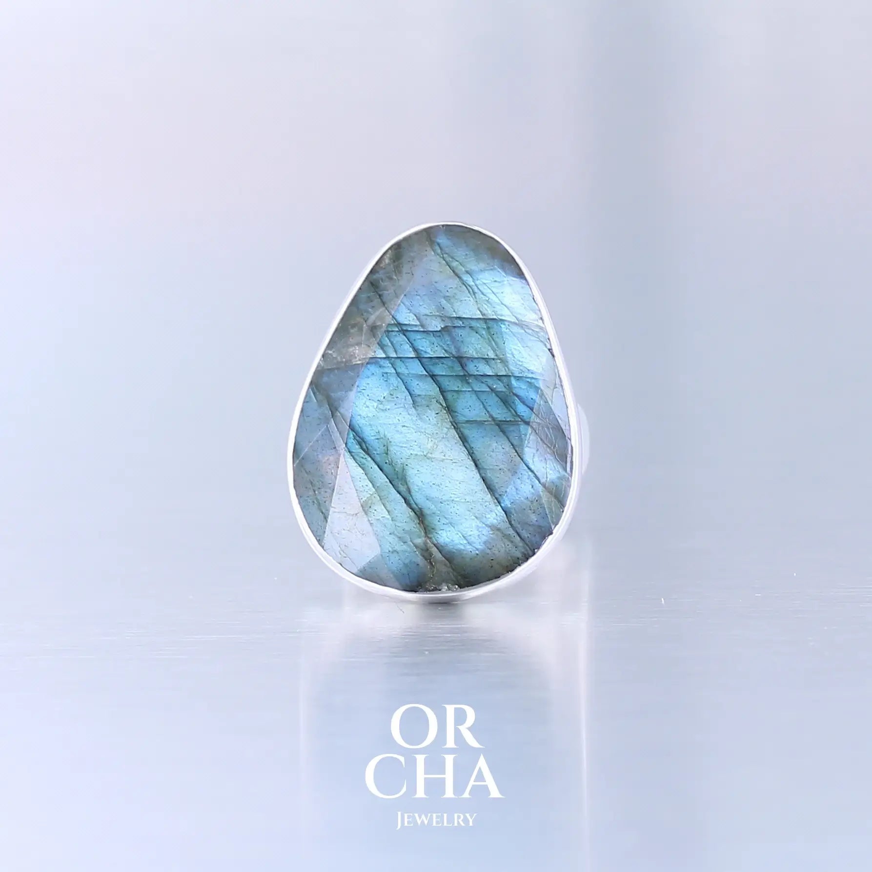 Bague pour femme en argent massif sertie d'une labradorite aux reflets bleus selon la lumière. Pierre facettée naturelle translucide présentant des inclusions fréquents sur ce type de pierre. Taille 58. Bijoux unique, éthique et durable présenté dans un coffret de notre marque, prêt à offrir. Livraison offerte, certificat d'authenticité, service client.
