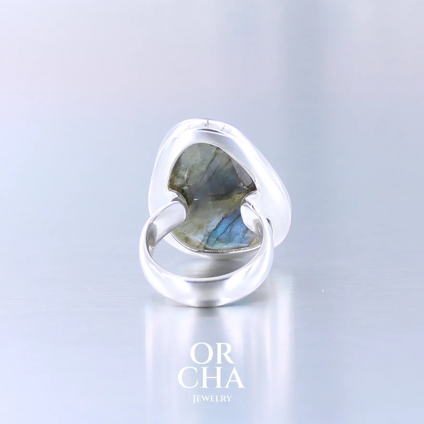 Bague pour femme en argent massif sertie d'une labradorite aux reflets bleus selon la lumière. Pierre facettée naturelle translucide présentant des inclusions fréquents sur ce type de pierre. Taille 58. Bijoux unique, éthique et durable présenté dans un coffret de notre marque, prêt à offrir. Livraison offerte, certificat d'authenticité, service client.