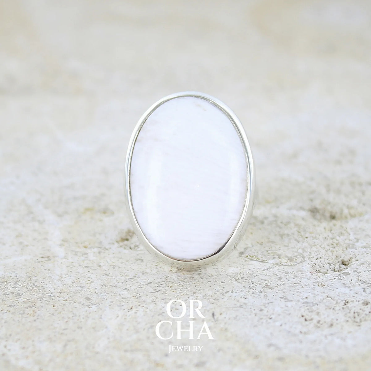 Bague pour femme en argent massif sertie d'un cabochon ovale de scolecite blanche. Pierre naturelle de qualité opaque. Bague unique réalisée en taille 54 par Orcha jewelry
