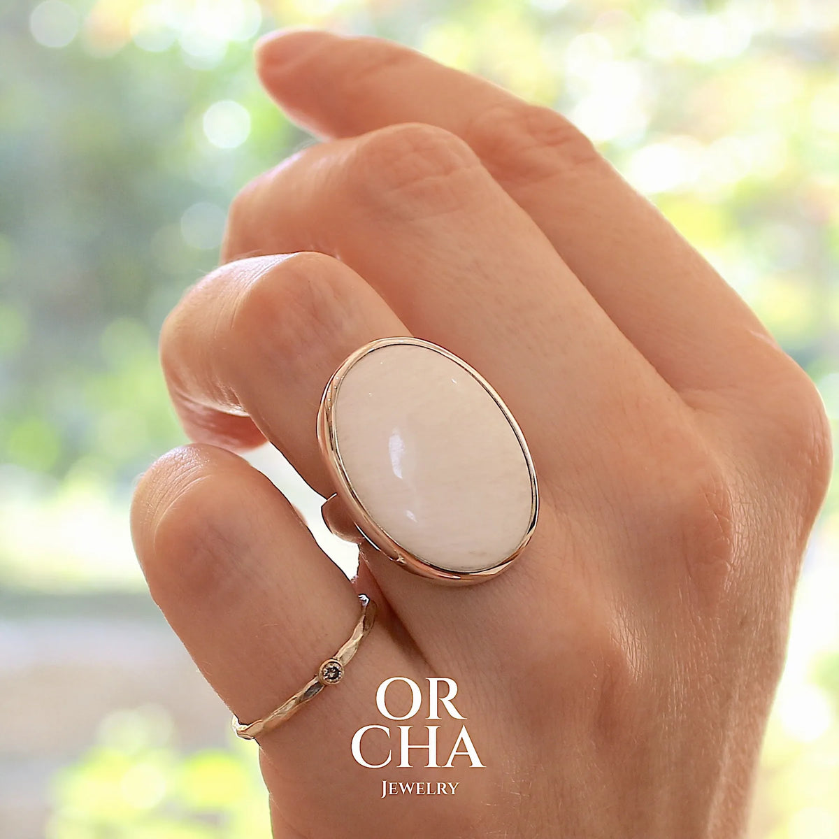 Bague pour femme en argent massif sertie d'un cabochon ovale de scolecite blanche. Pierre naturelle de qualité opaque. Bague unique réalisée en taille 54 par Orcha jewelry