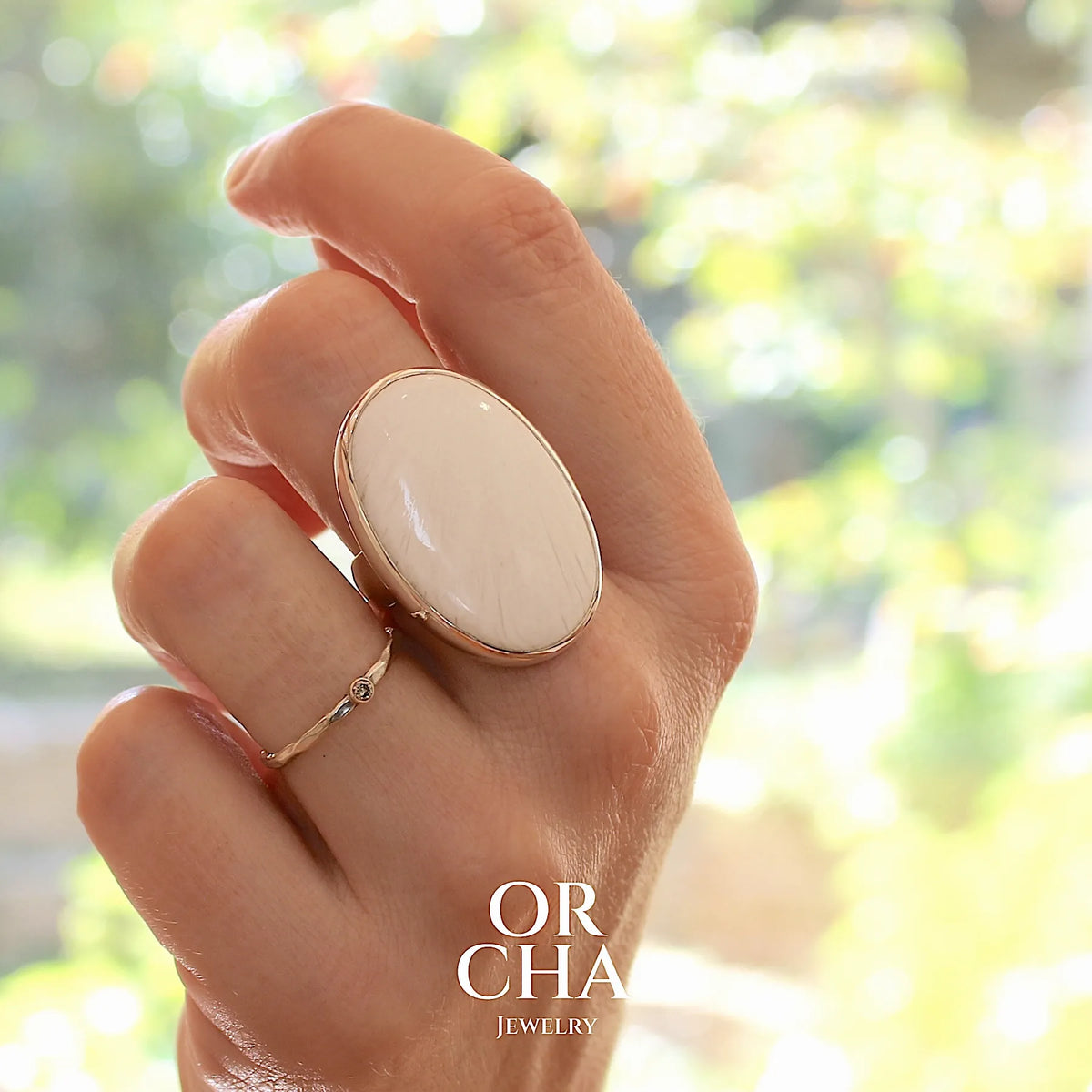 Bague pour femme en argent massif sertie d'un cabochon de scolecite de couleur blanc pur. Pierre naturelle de qualité opaque taillée en ovale. Bague unique réalisée en taille 58 par Orcha jewelry