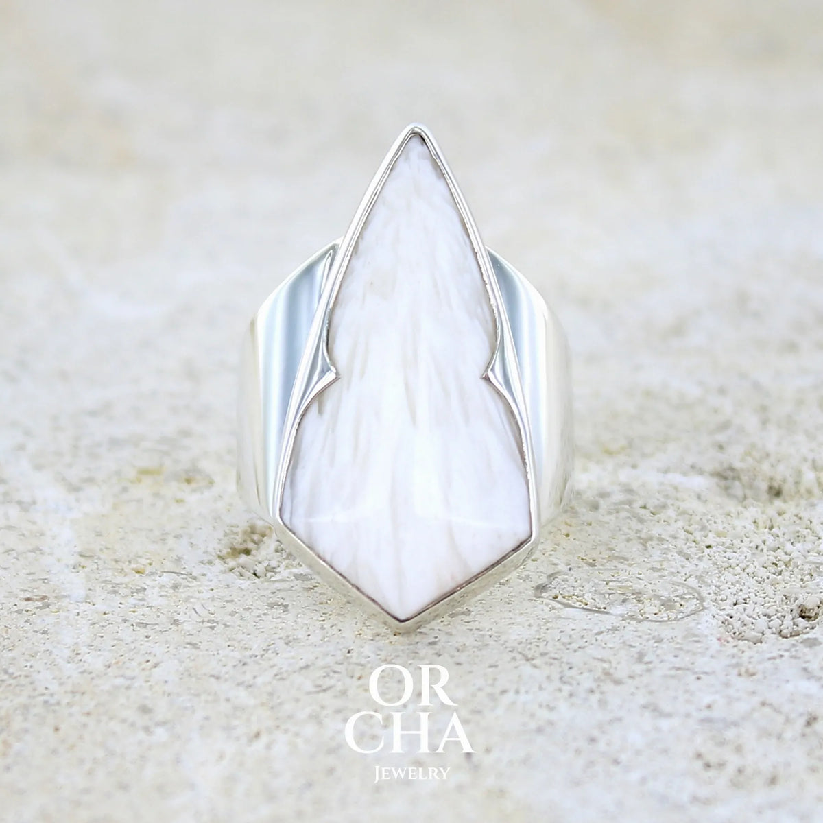Bague contemporaine pour femme en argent massif sertie d'une scolecite blanche. Pierre naturelle de qualité opaque taillée en forme de losange. Bague unique réalisée en taille 56 par Orcha jewelry