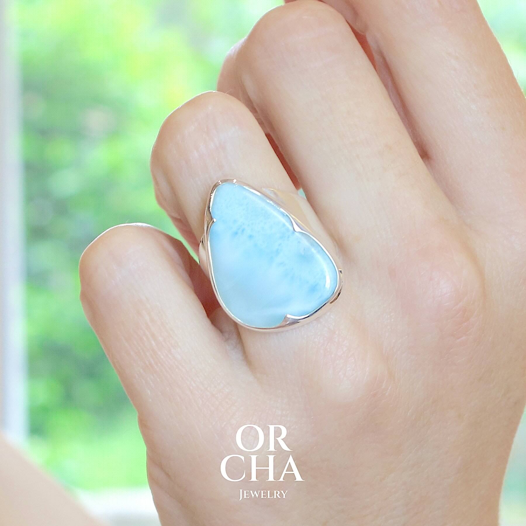 Bague de créateur pour femme en argent massif sertie d'un Larimar de République dominicaine. Cabochon de forme fantaisie, pierre naturelle de couleur bleu clair présentant de légère marbrures blanches. Qualité translucide. Taille 54. Bijoux unique, éthique et durable présenté dans un coffret de notre marque, prêt à offrir. Livraison offerte, certificat d'authenticité, service client.
