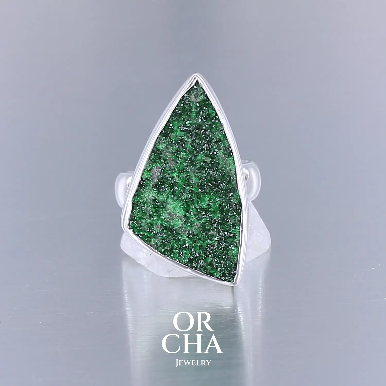 Bague en argent massif sertie d'un grenat Uvarovite brute. Pierre naturelle recouverte de cristaux scintillants de couleur verte. Bague réalisée en taille 58,5. Bijoux unique, éthique et durable présenté dans un coffret de notre marque, prêt à offrir. Livraison offerte, certificat d'authenticité, service client.