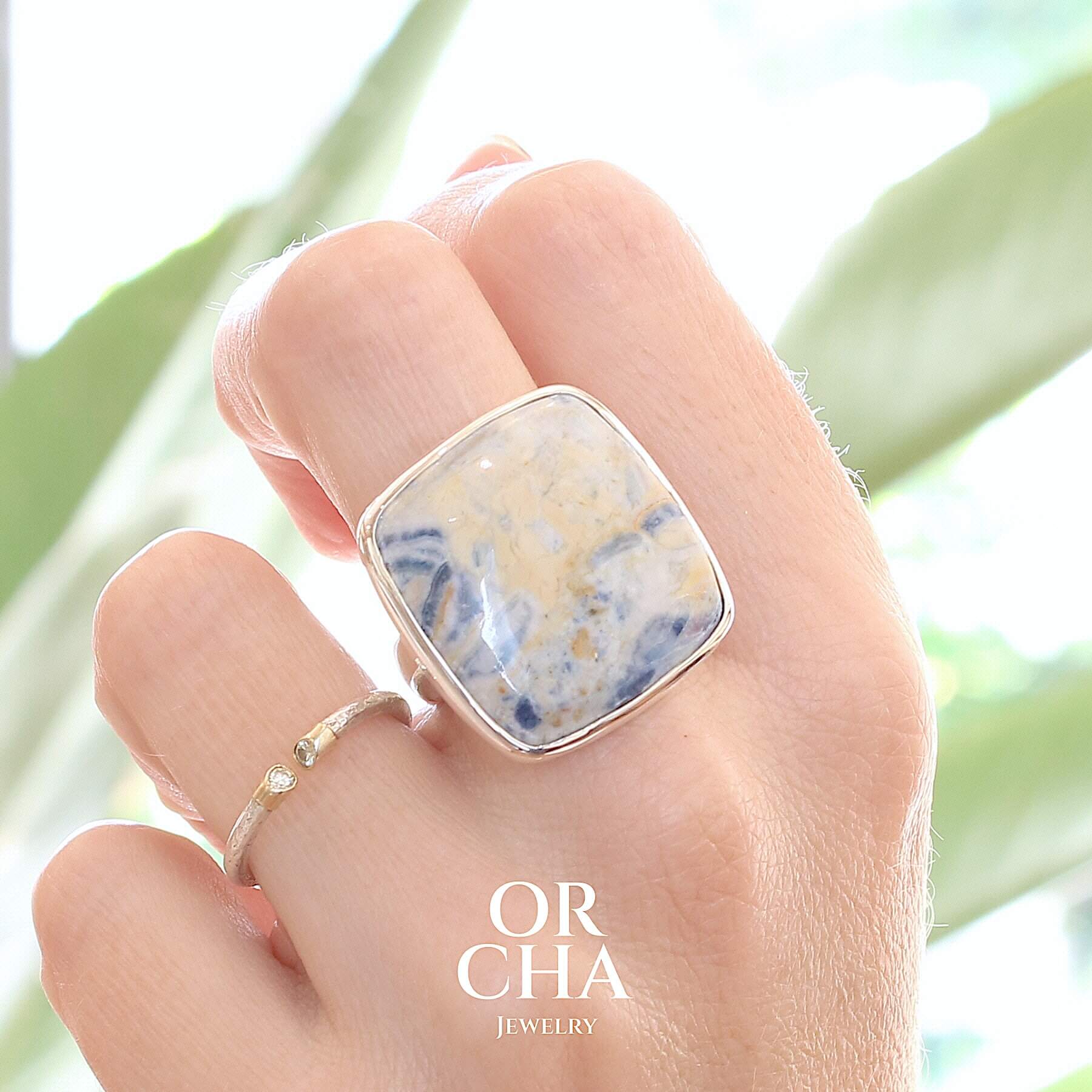 Bague carrée pour femme en argent massif sertie d'une scheelite bleue. Pierre naturelle de couleur bleu, beige creme et blanc de qualité  opaque. Taille 60. Bijoux unique, éthique et durable présenté dans un coffret de notre marque, prêt à offrir. Livraison offerte, certificat d'authenticité, service client.